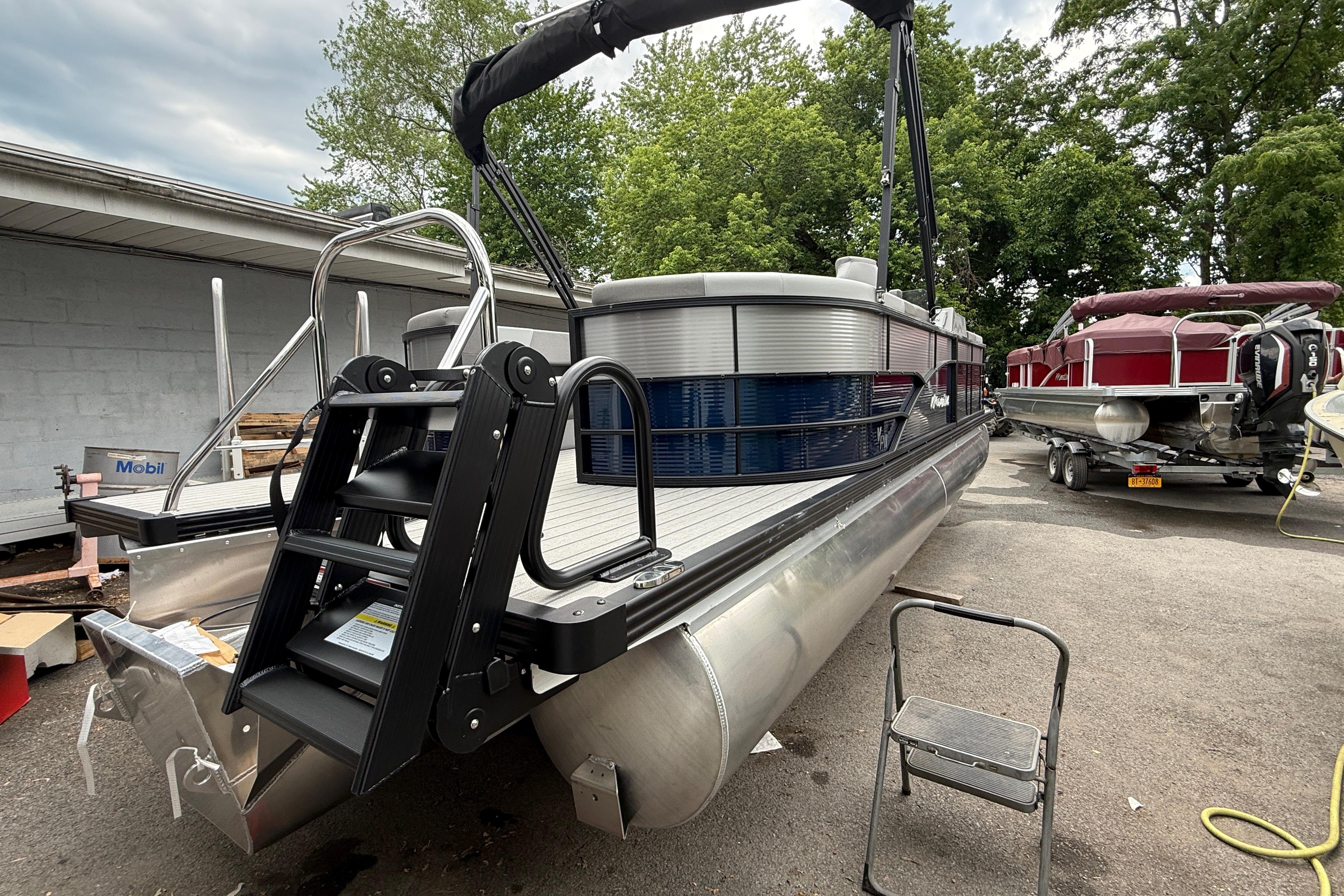 2027 Manitou Aurora RF 23 pontoon boat with sleek design and sturdy ladder.