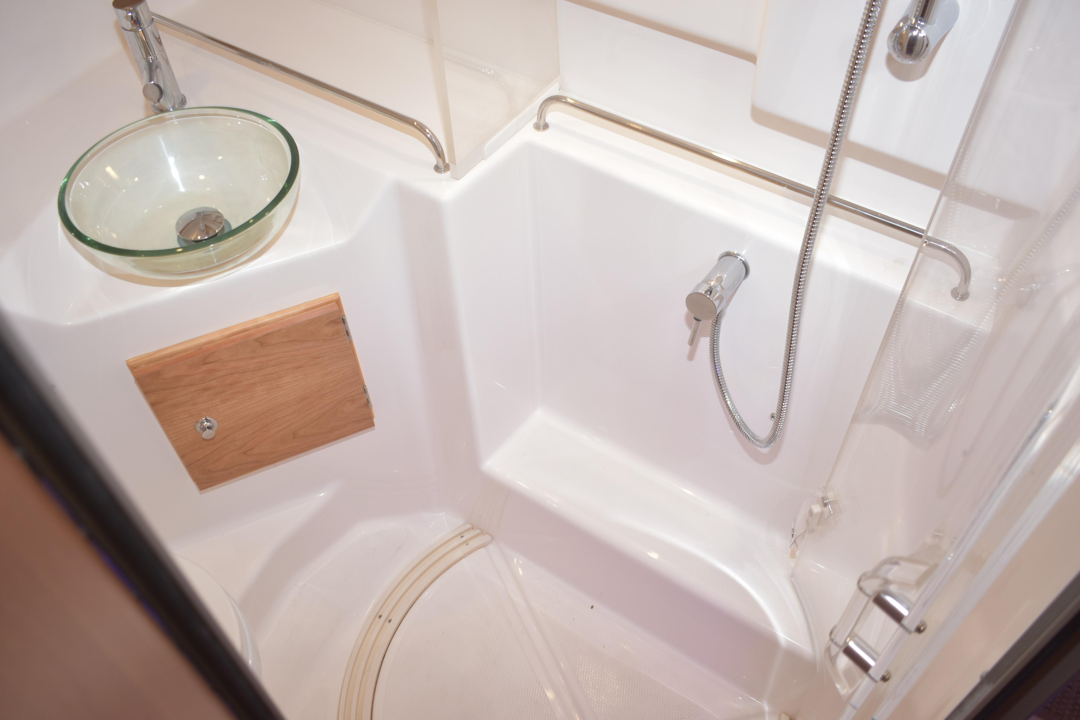 2026 Cutwater C-32 CB yacht bathroom with glass sink and shower.
