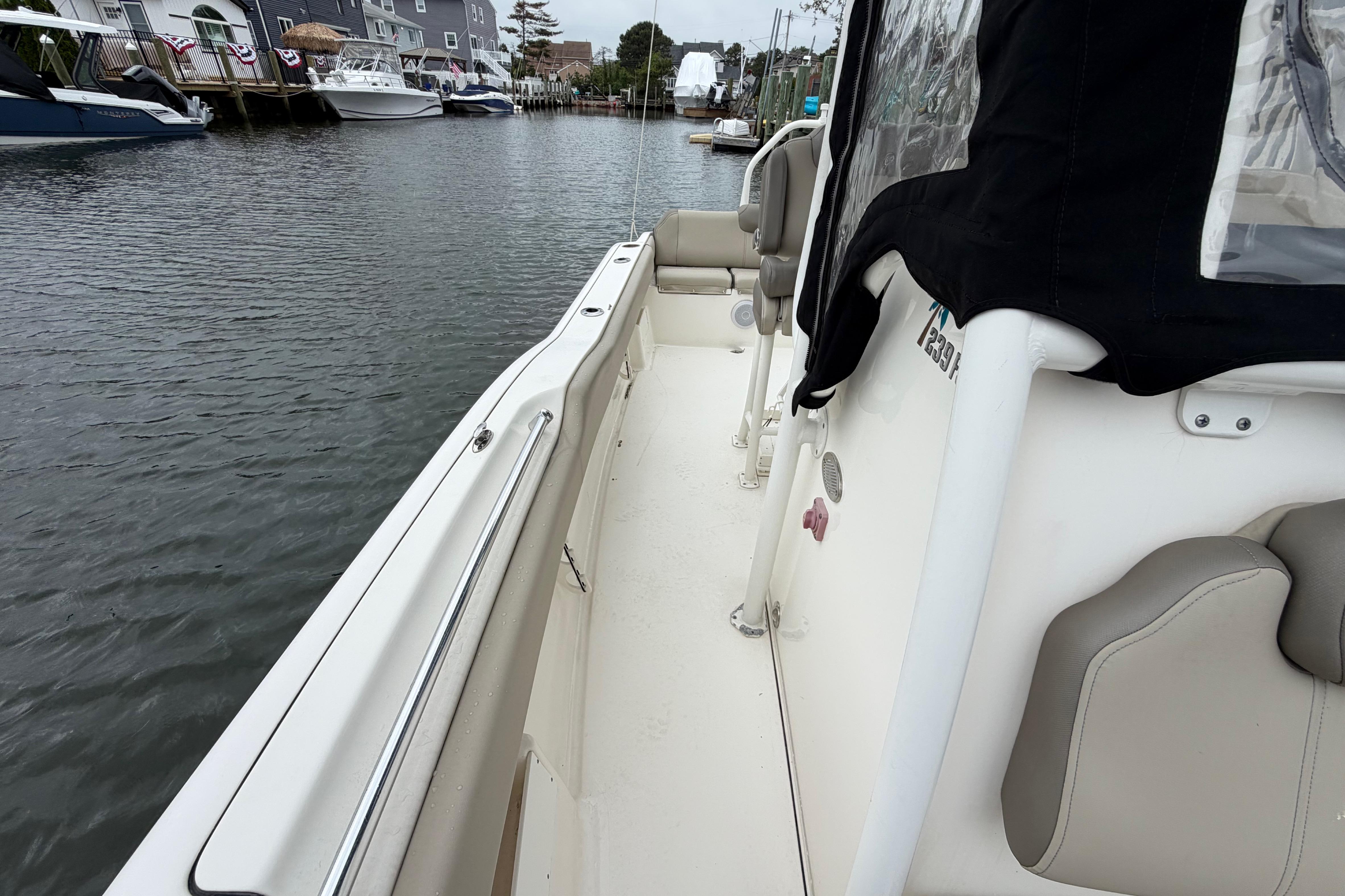 2022 Key West 239 FS boat docked in a marina, showcasing sleek design and comfortable seating.