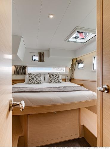 Luxurious cabin interior of 2025 Lagoon 42 Millenium yacht, featuring a cozy bed and modern design.