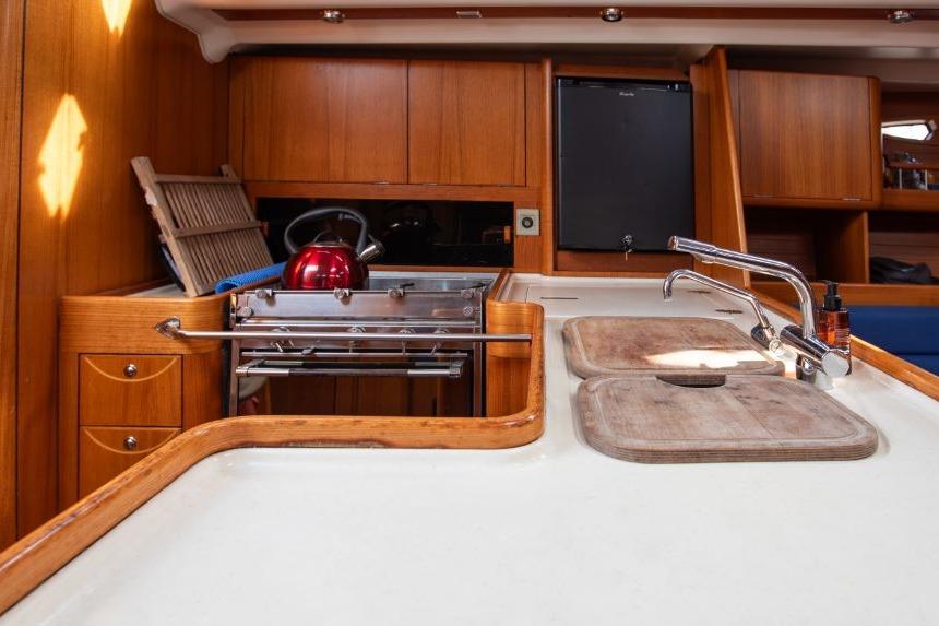 Interior of 2005 X-Yachts 50, featuring a wooden kitchen with sink and stove.