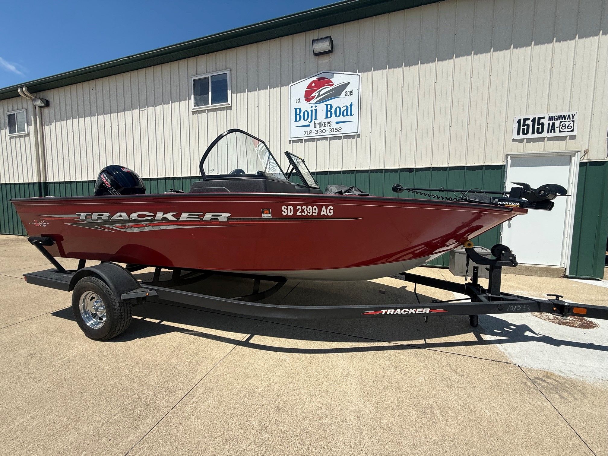 2024 Tracker Pro Guide V175 boat on trailer in front of building.