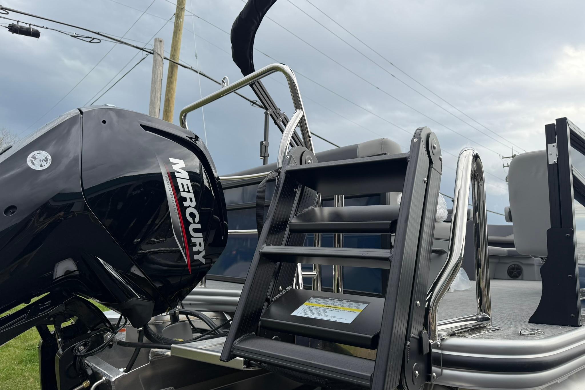 2026 Lowe LS 190 boat with Mercury engine and ladder, under cloudy sky.