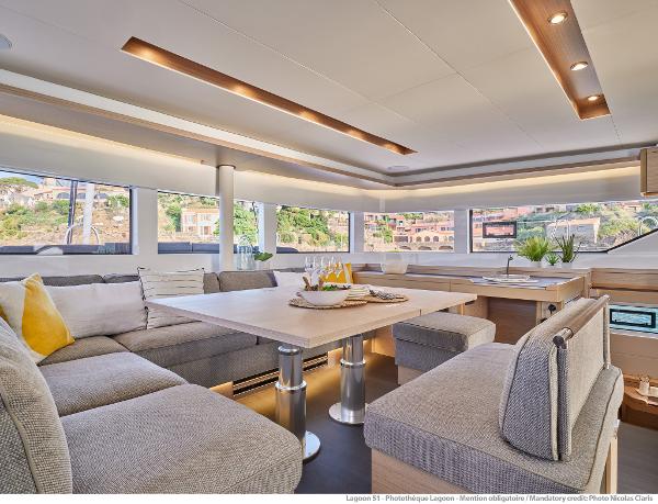 Luxurious interior of 2025 Lagoon 51 ICONIC yacht with modern seating and dining area.