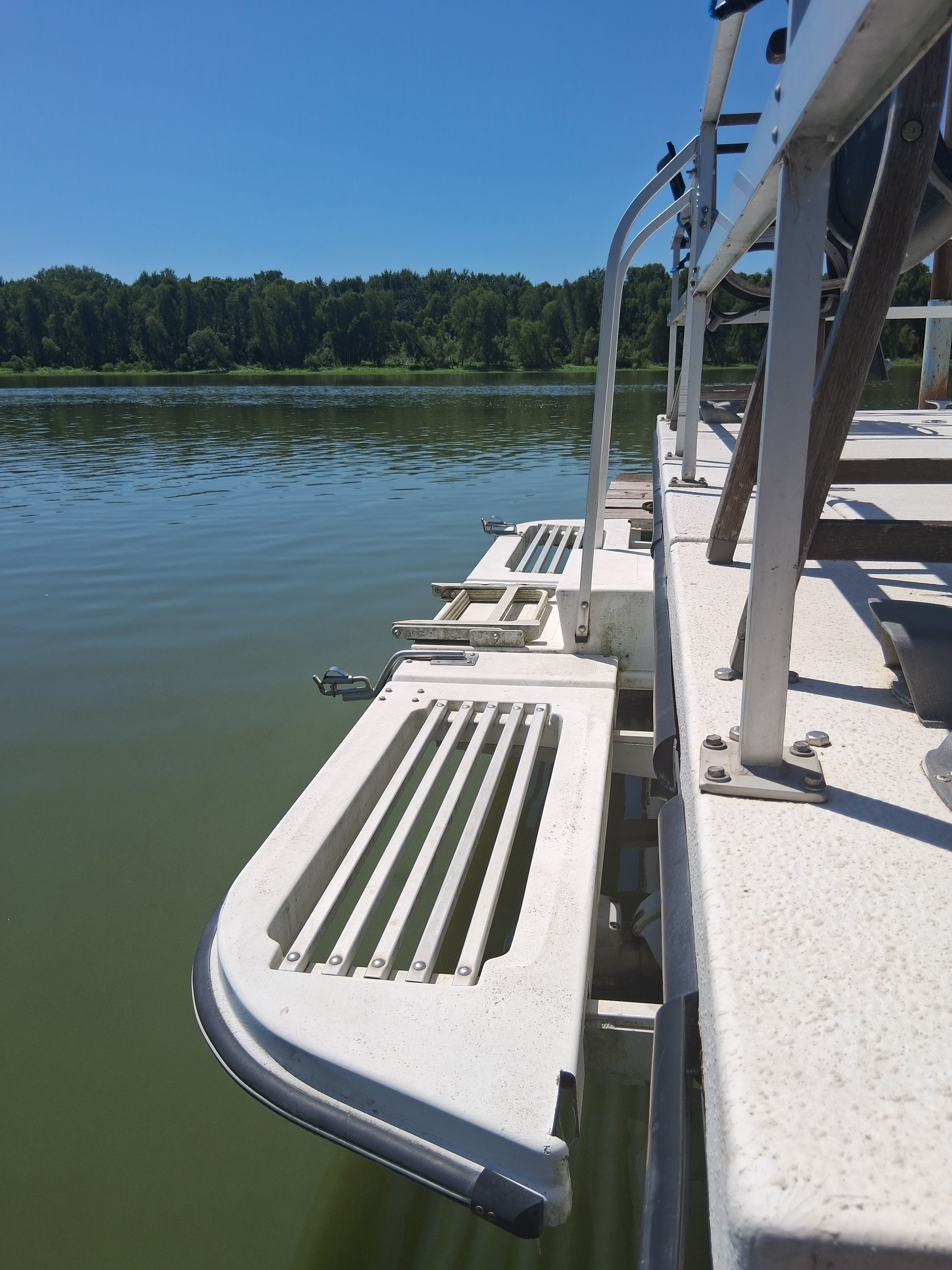 The image shows the deck of a 1993 Gibson 370 Sport, situated on a calm lake.