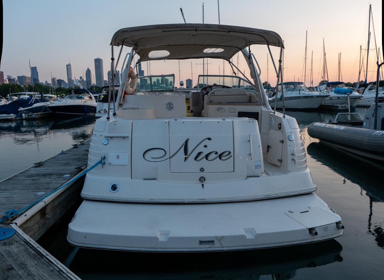 2006 Rinker Fiesta Vee 300 boat docked at marina during sunset.