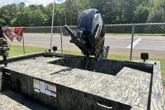 2026 Tracker Grizzly 1860 Utility boat with Mercury outboard motor, parked outdoors.