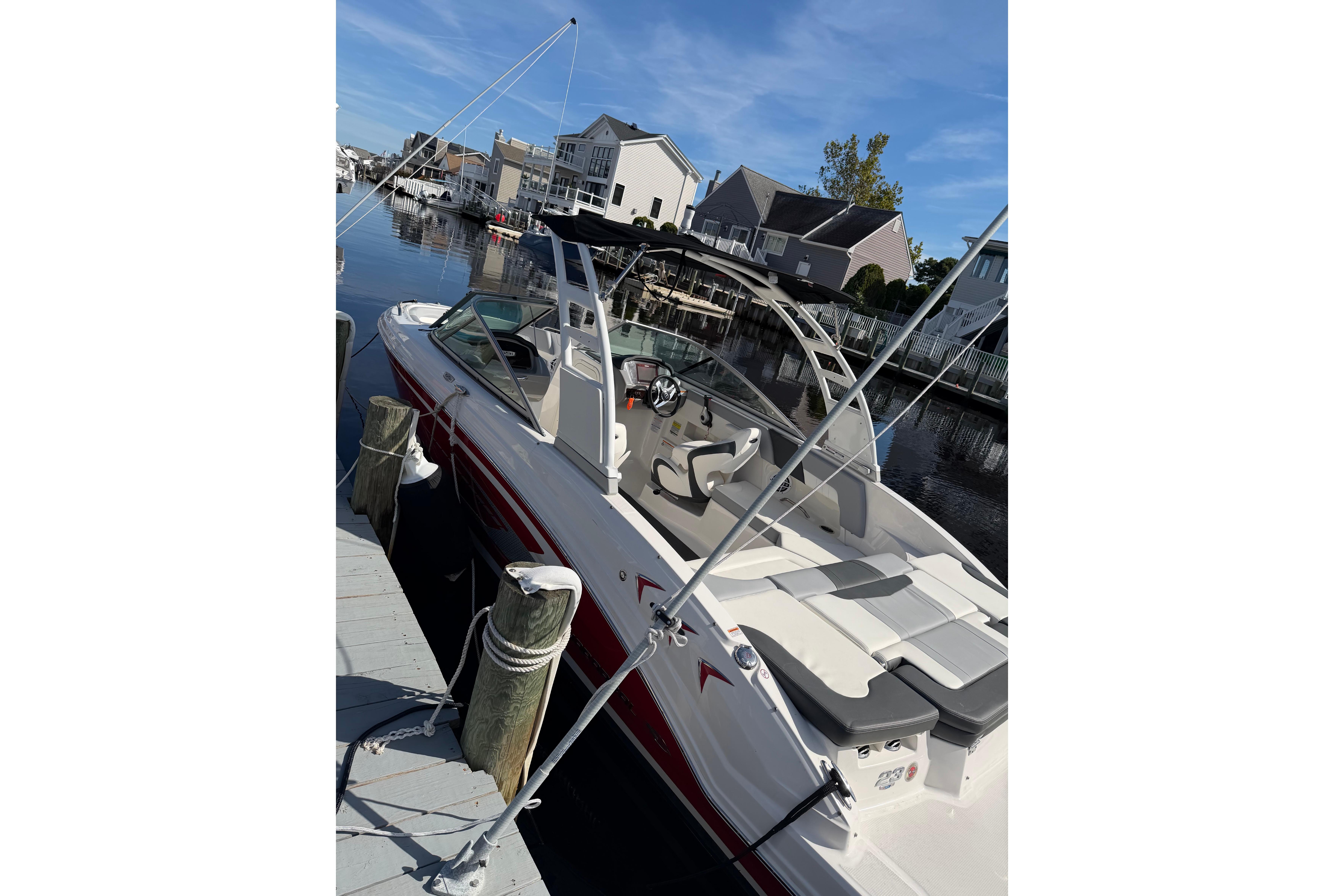 2024 Chaparral 23 SSi OB boat docked in a scenic waterfront setting.