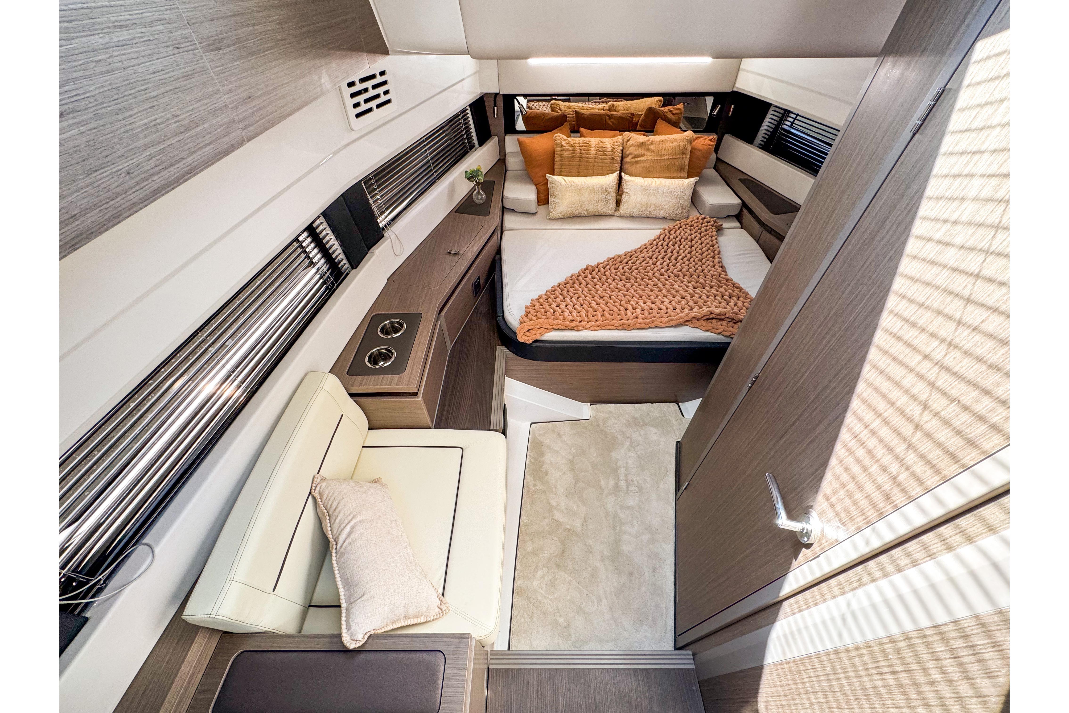 Luxurious interior of 2025 Wellcraft 38 Explorer yacht with cozy bed and seating area.