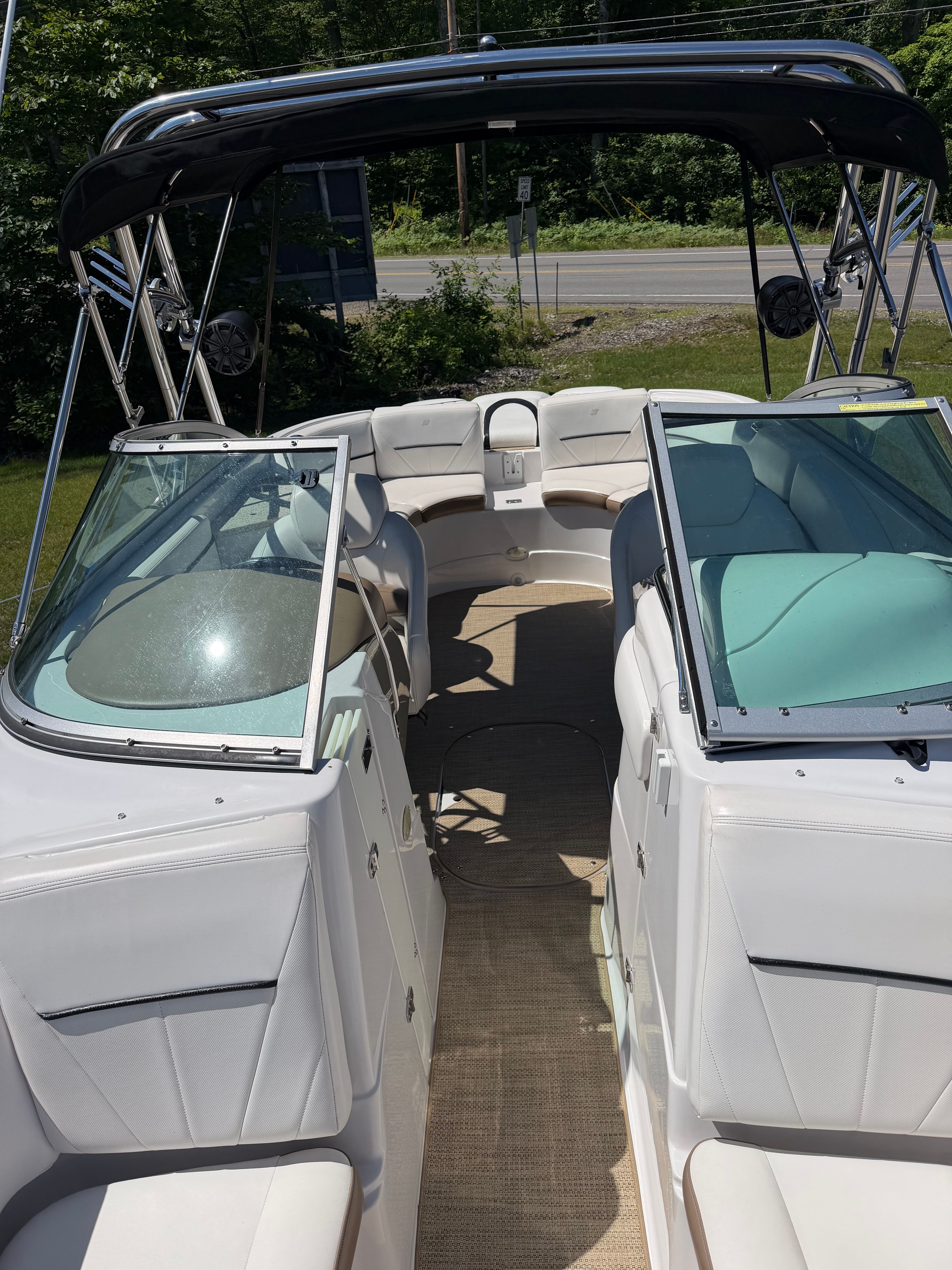 The image shows the cockpit of a Four Winns H240 Frenzy boat with open windshields.