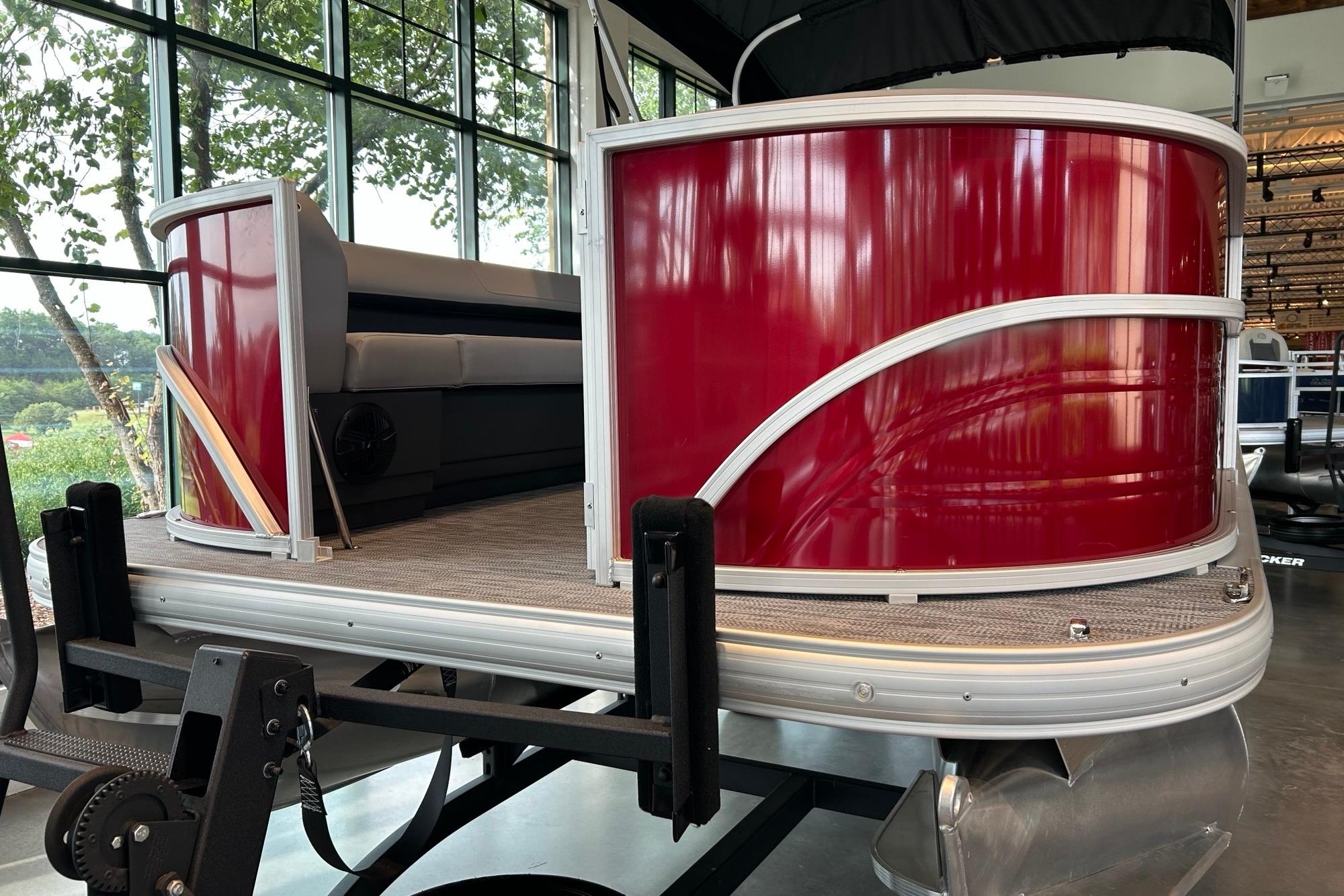 2026 Sun Tracker Party Barge 18 DLX pontoon boat with red exterior in showroom.