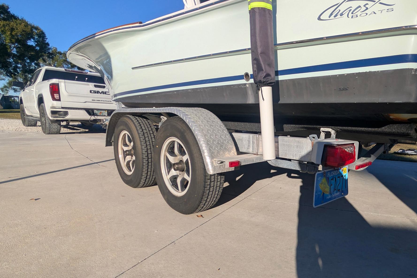 2017 Chaos 21 Tarpon Bay boat on trailer, hitched to a white GMC truck.