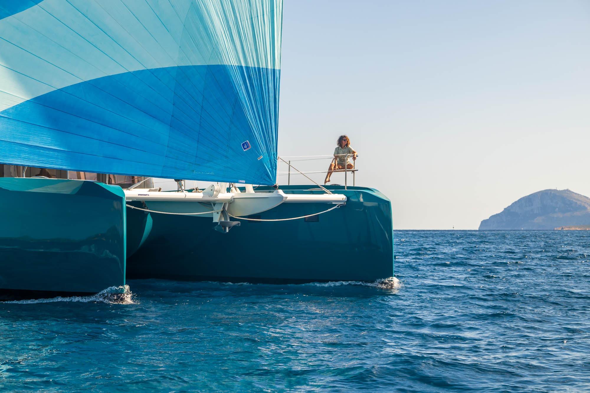 2026 Lagoon Eighty 2 catamaran sailing with blue sail on open sea.