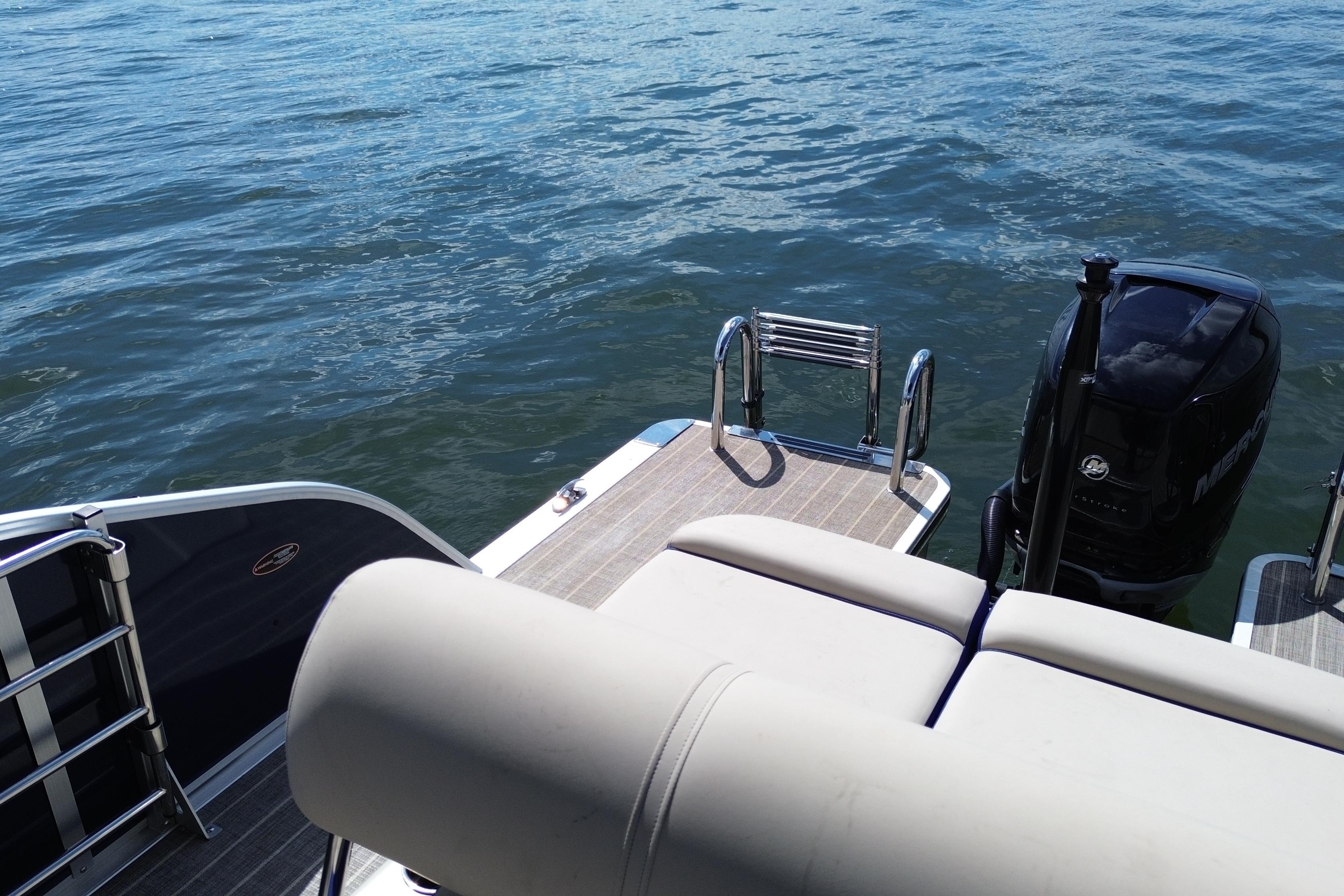 2022 Harris Grand Mariner 250 boat with outboard motor on calm water.