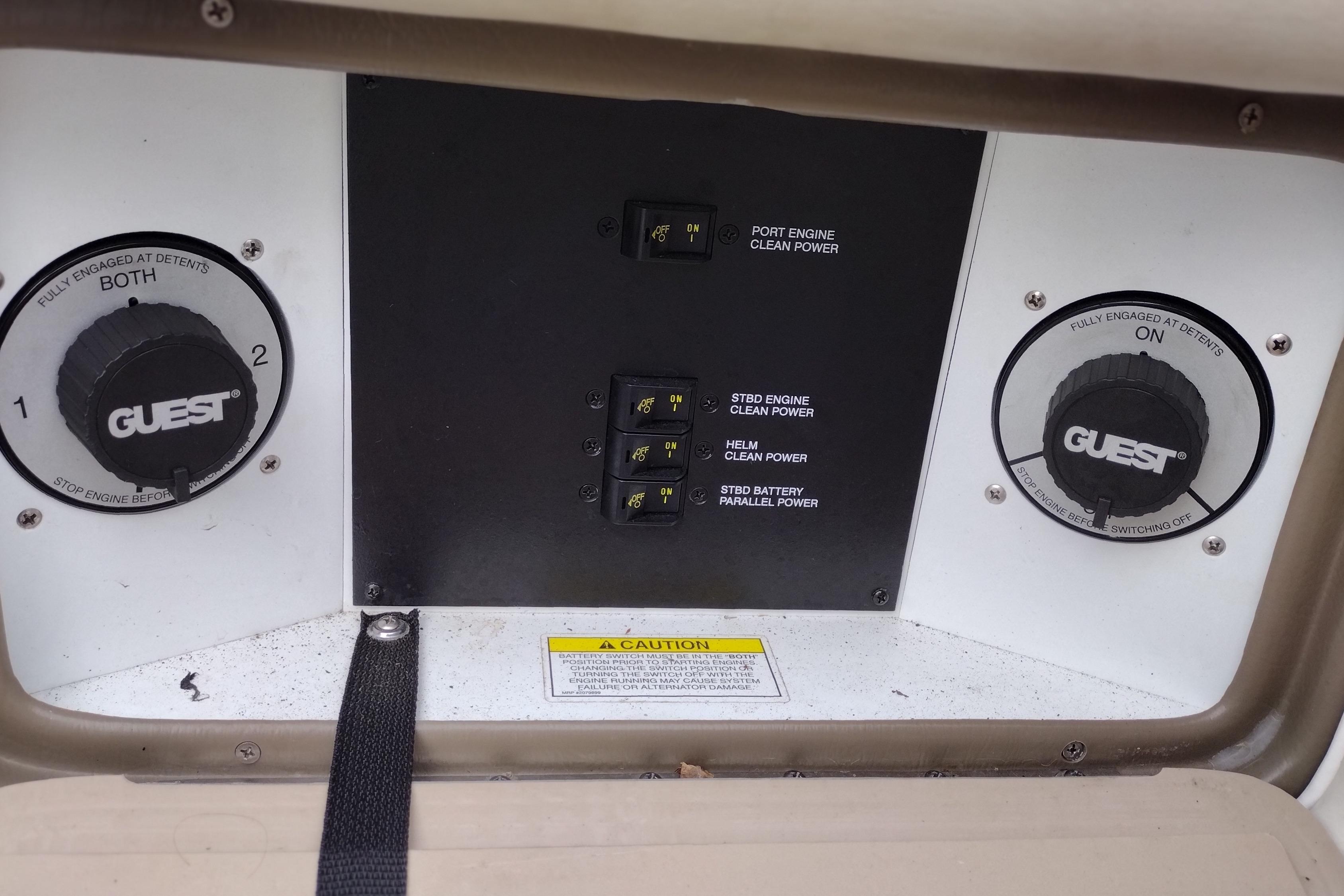 Control panel of a 2013 Sea Ray 300 SLX boat with power switches and dials.