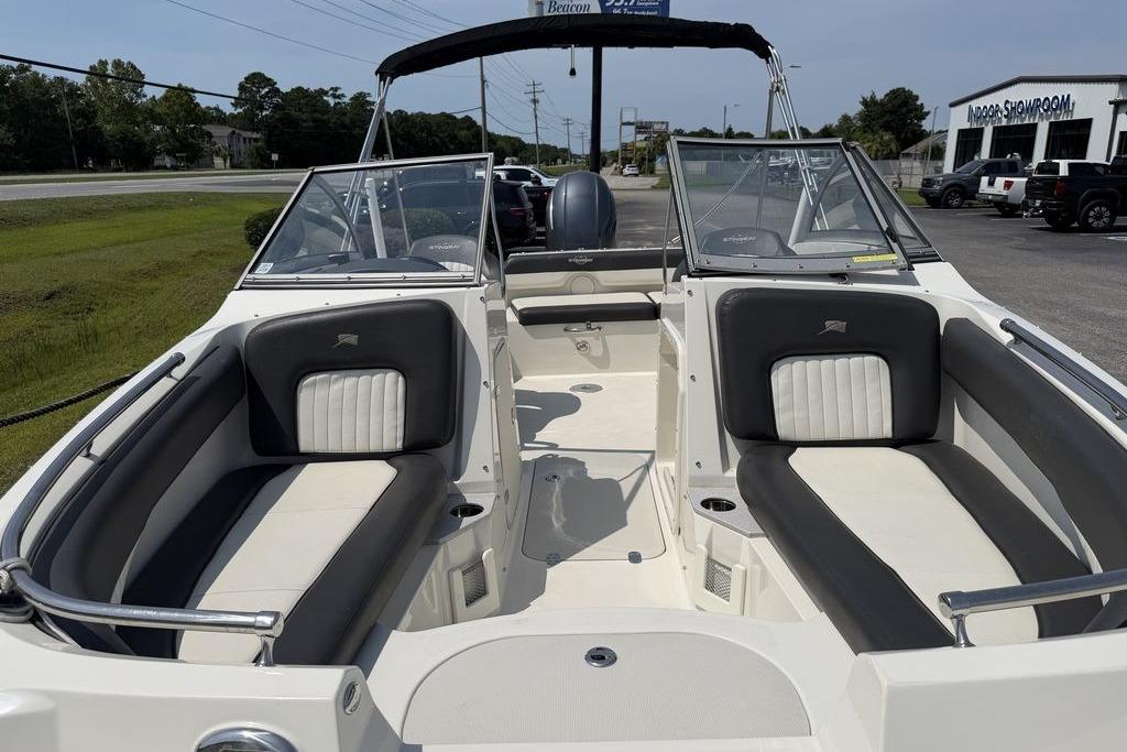 2019 Stingray 201 DS boat interior with seating and windshield, parked outdoors.