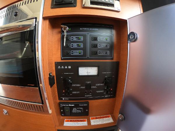 Control panel of a 2017 Jeanneau NC 11 boat with battery switches and warning labels.