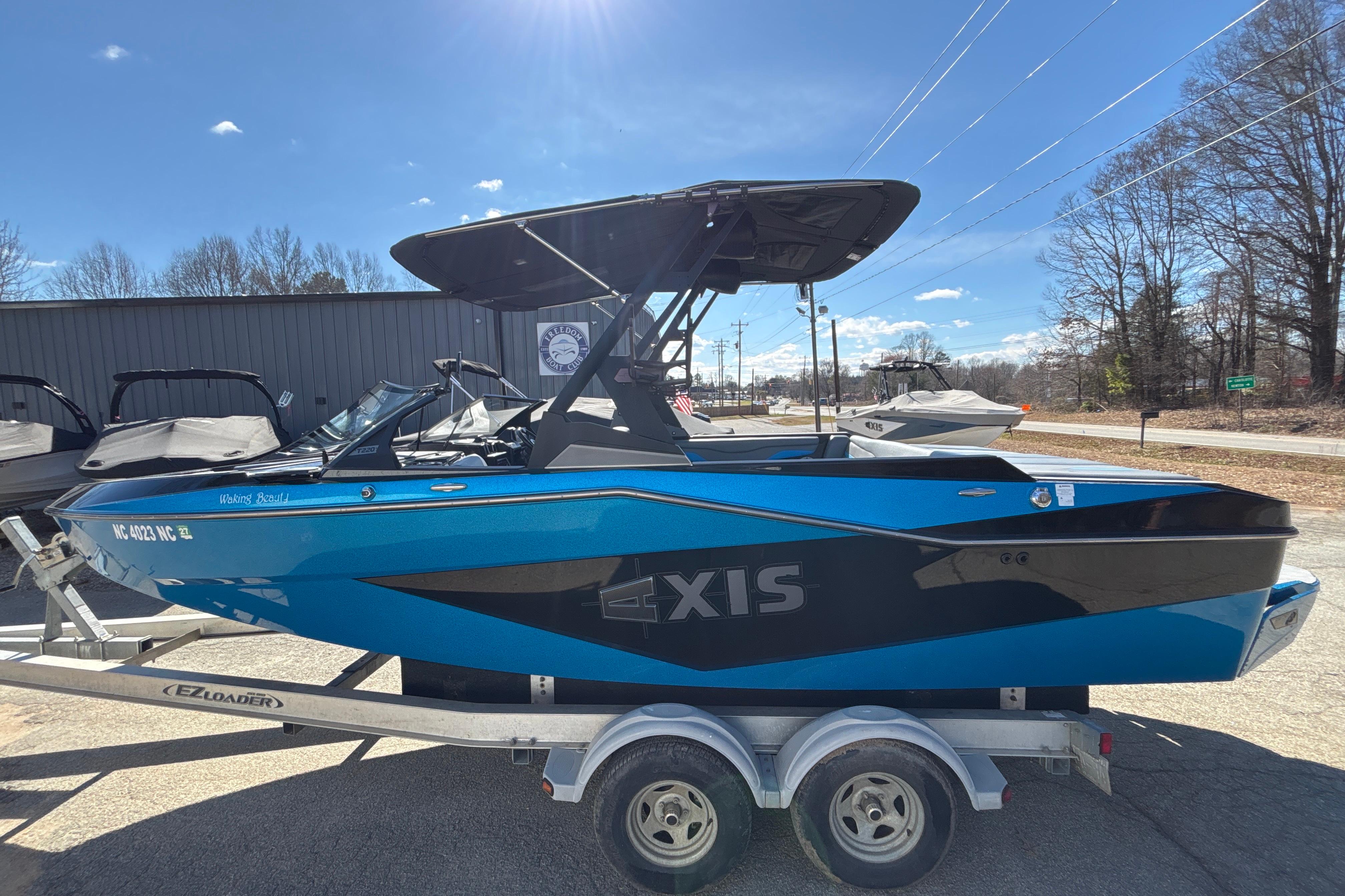 2023 Axis T220 boat in blue on trailer, sunny day, outdoor display.