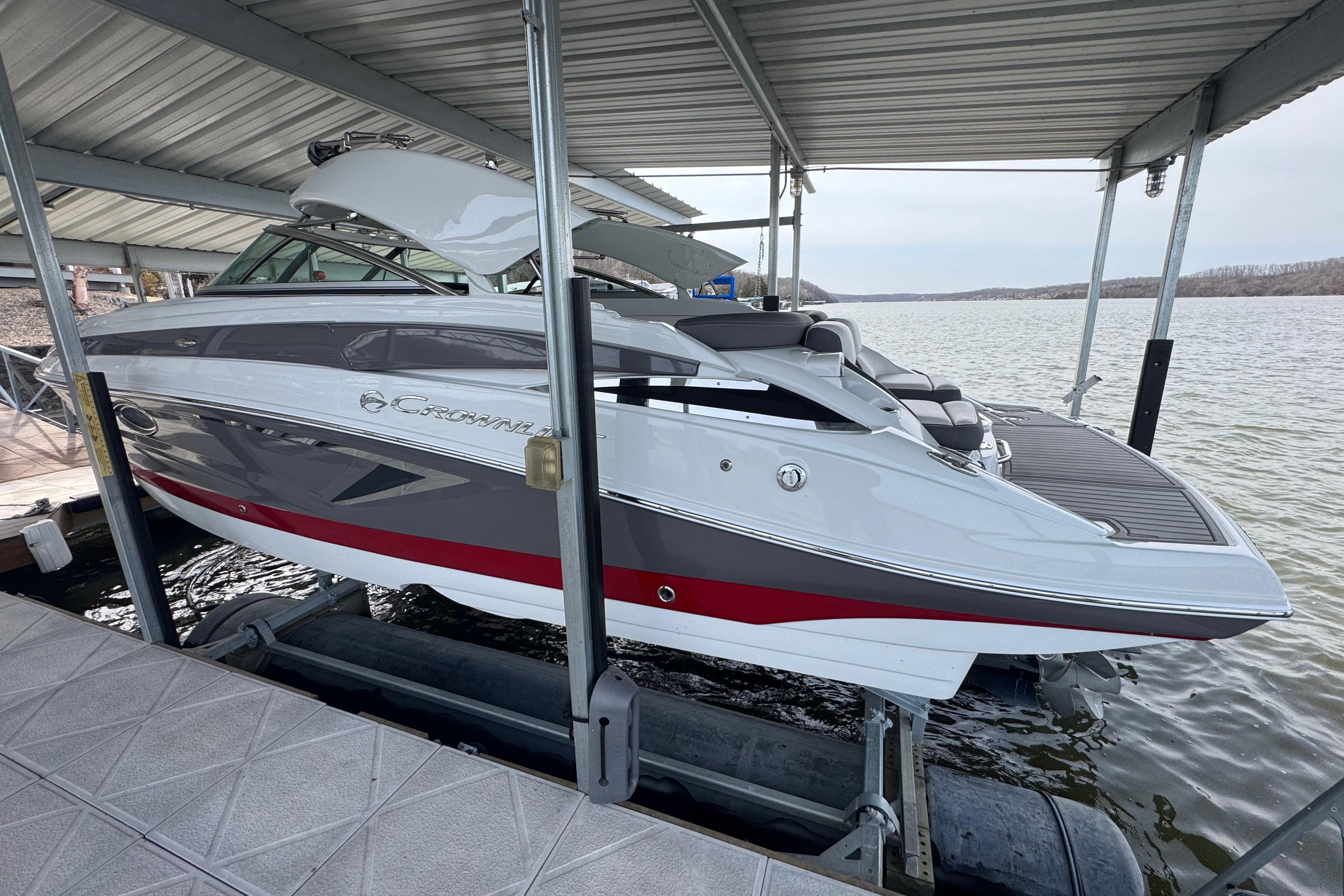 2022 Crownline 265 SS boat docked on a lake under a covered slip.