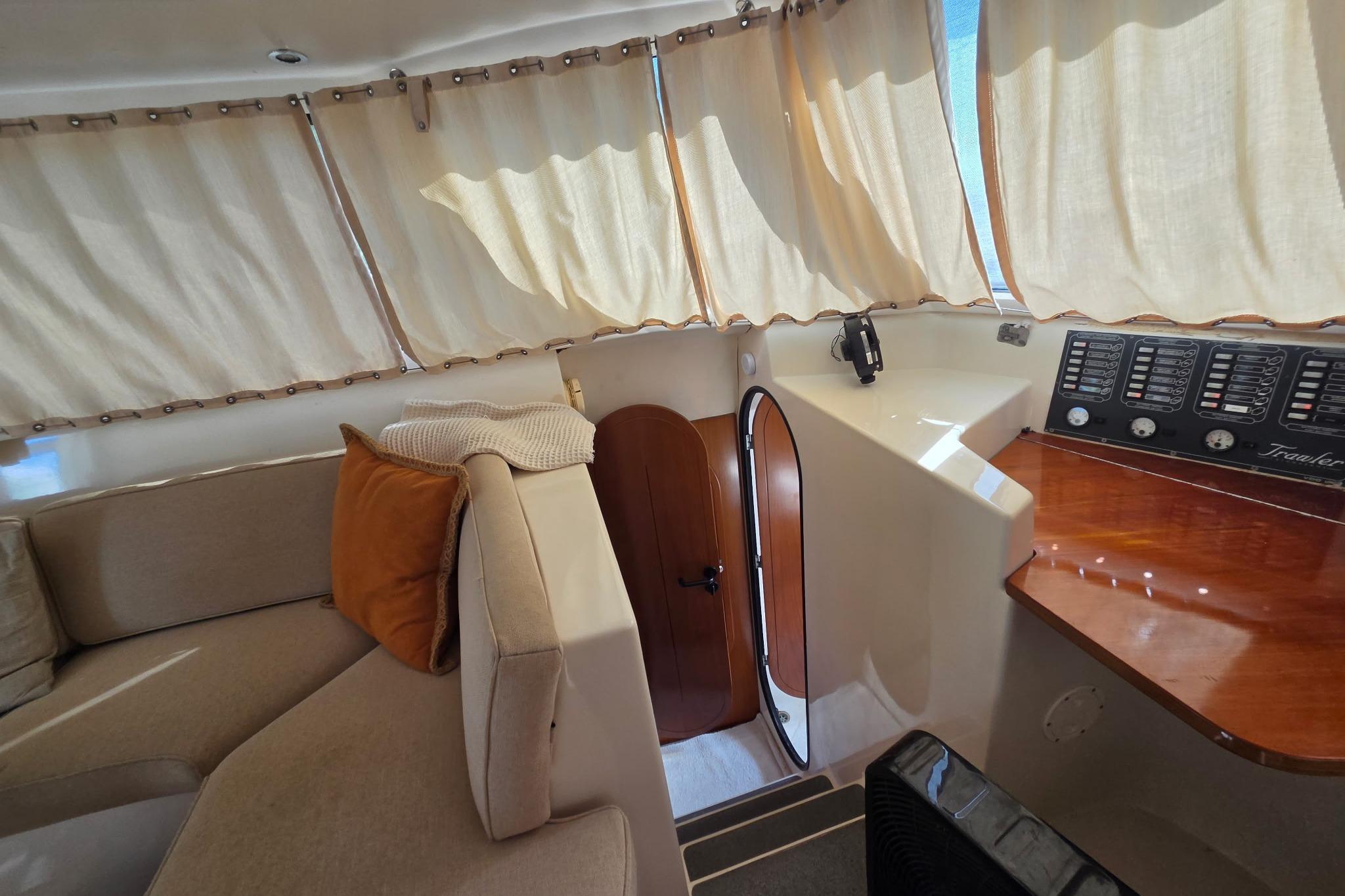 Interior of 2000 Fountaine Pajot Maryland 37 yacht with cozy seating and control panel.