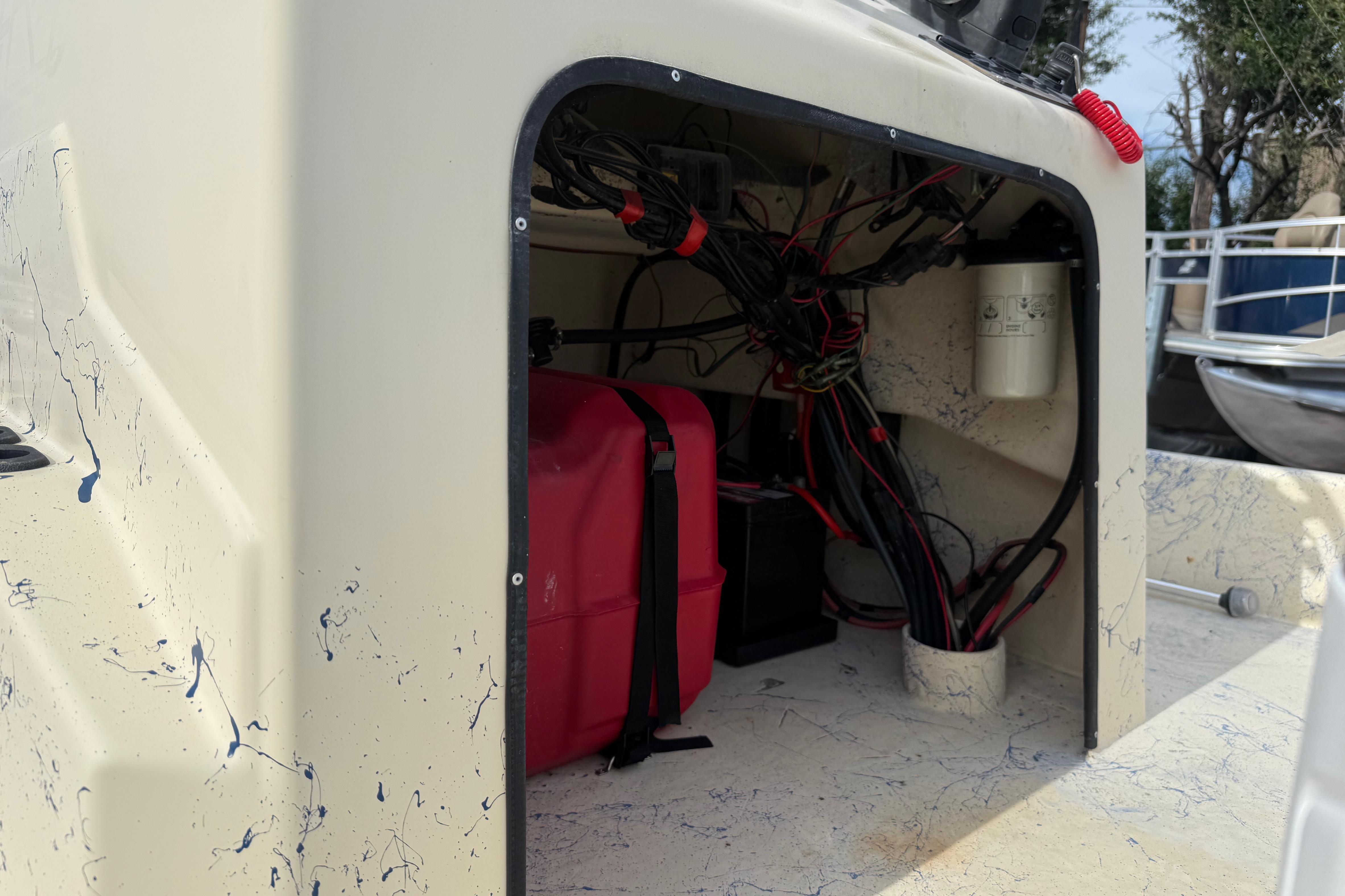 Interior view of a 2007 Flats Cat 19 boat showing wiring and storage compartment.