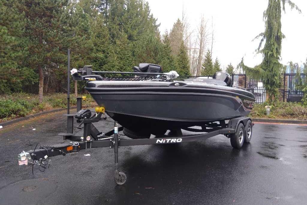2025 Nitro ZV19 boat on trailer in a wooded parking area.