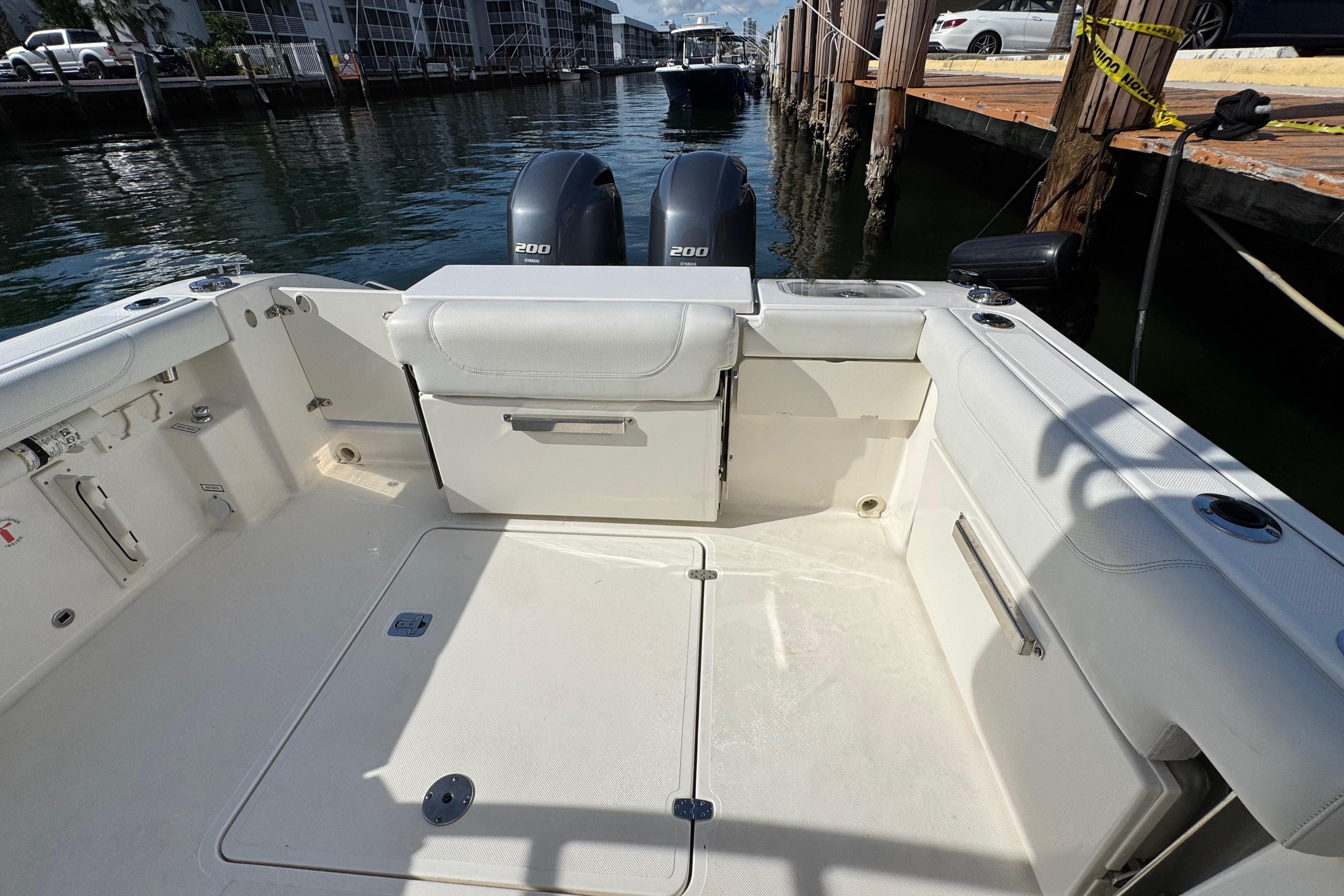 2022 Pursuit DC 266 Dual Console boat interior with twin 200 engines, docked by the water.