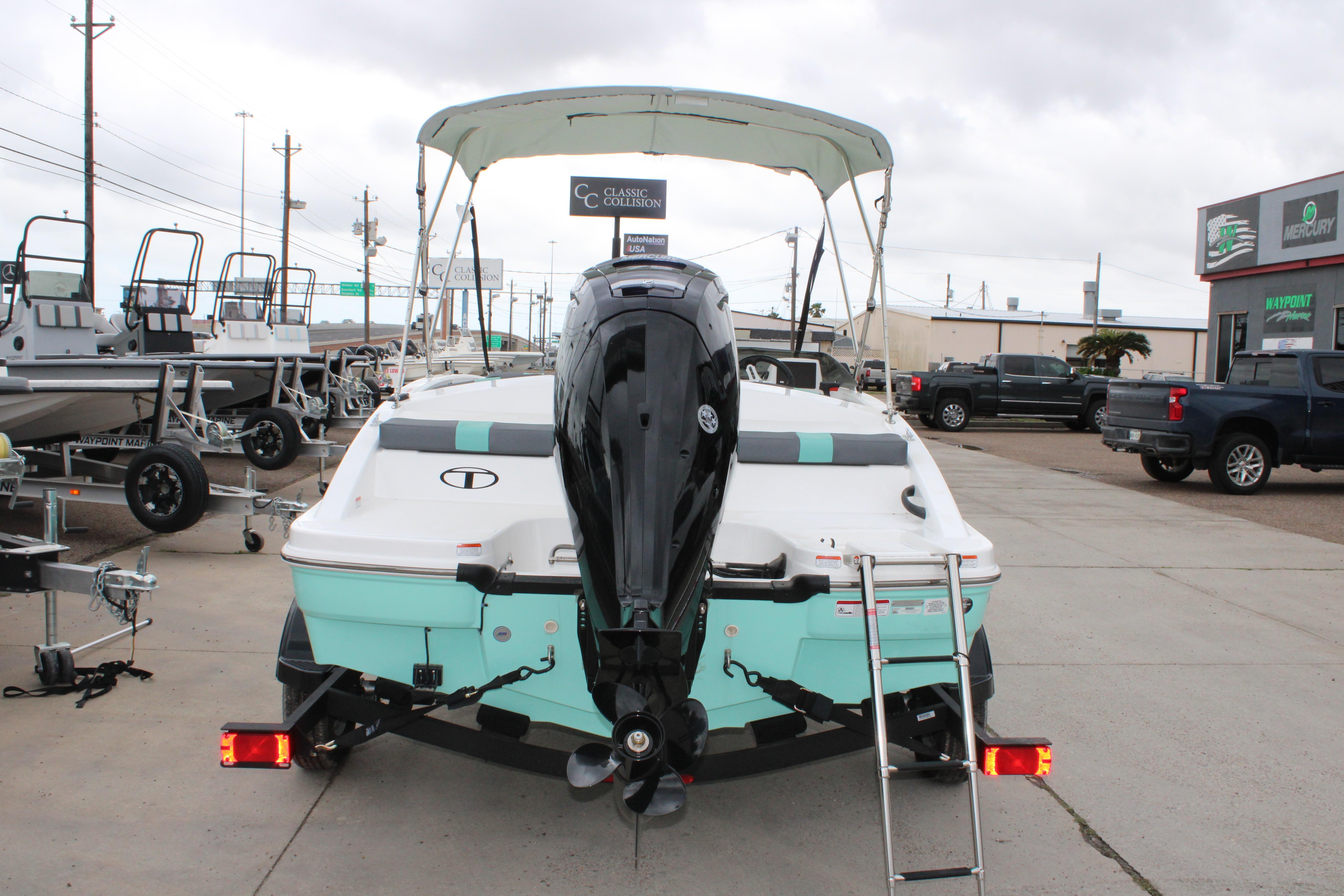 2026 Tahoe T16 boat with outboard motor and trailer in a dealership lot.