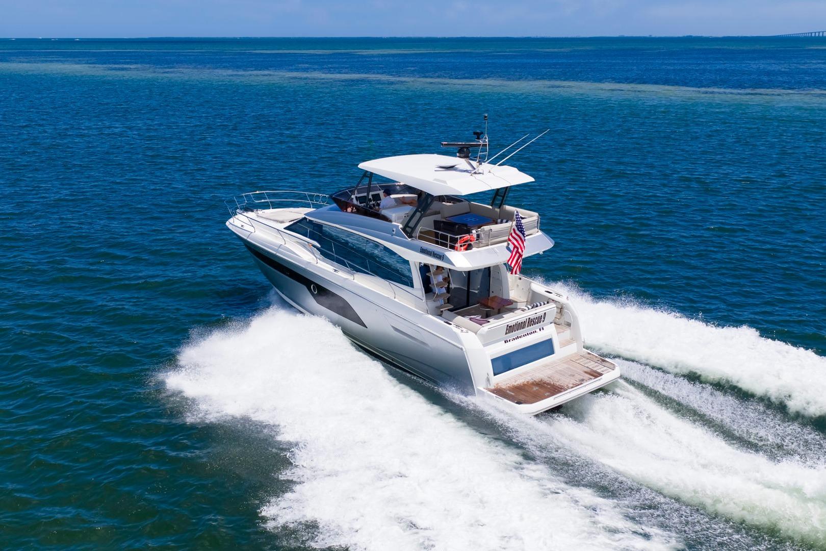 Luxury 2022 Prestige 520 yacht cruising on open blue ocean waters.