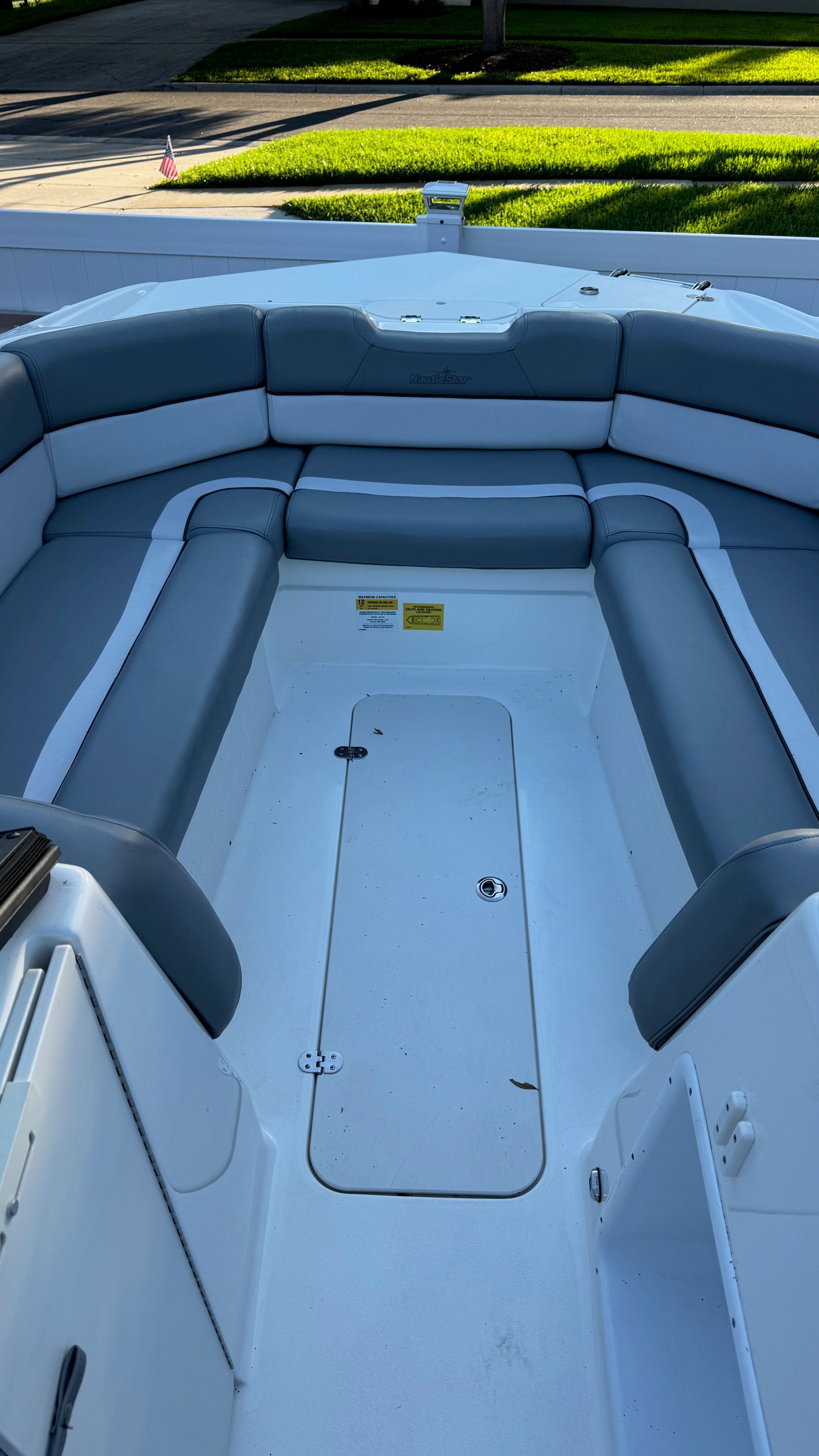 The image shows the bow area of a NauticStar 243 DC boat with gray upholstery.