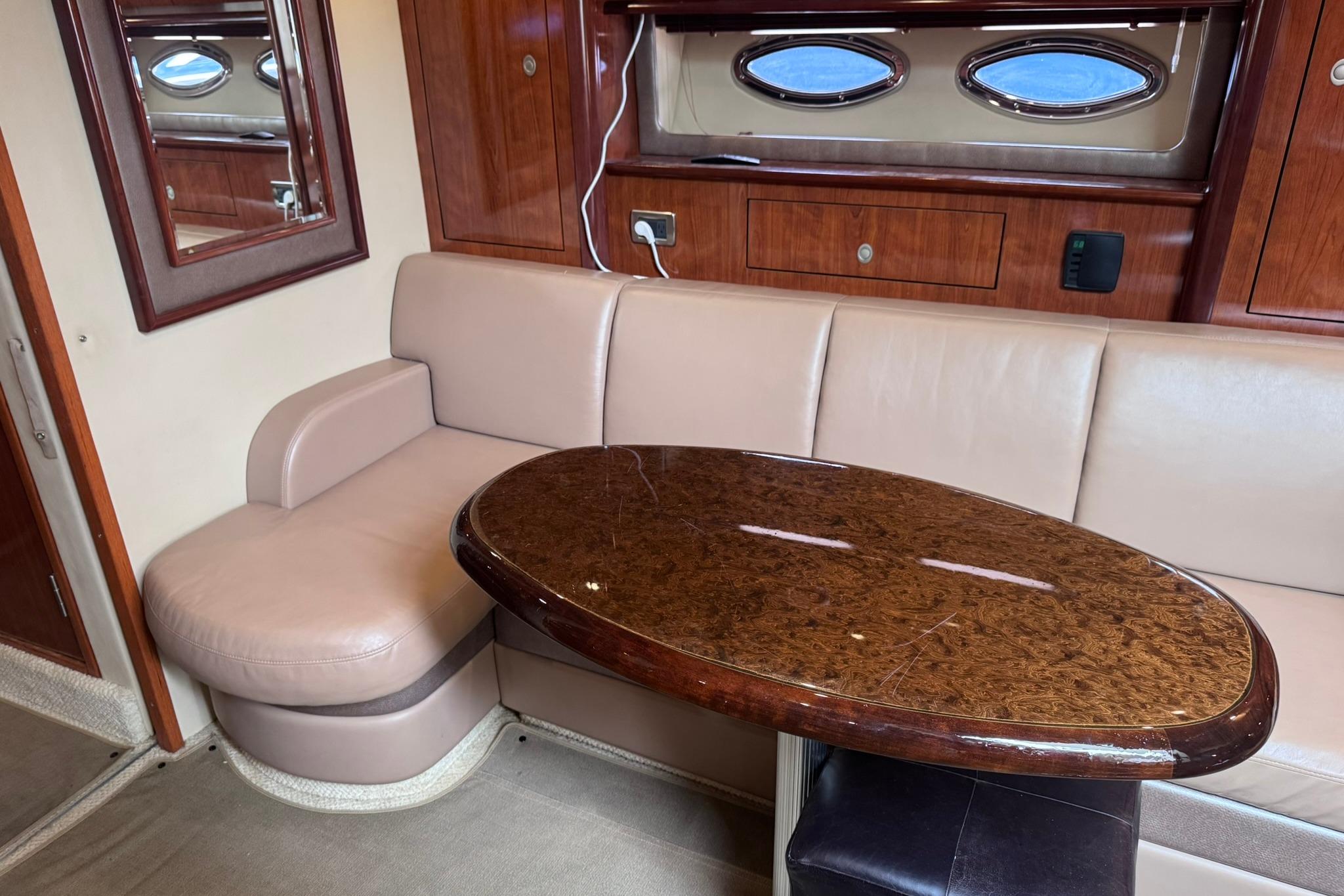 Luxurious interior of 2004 Sea Ray 390 Sundancer with elegant seating and polished wood table.