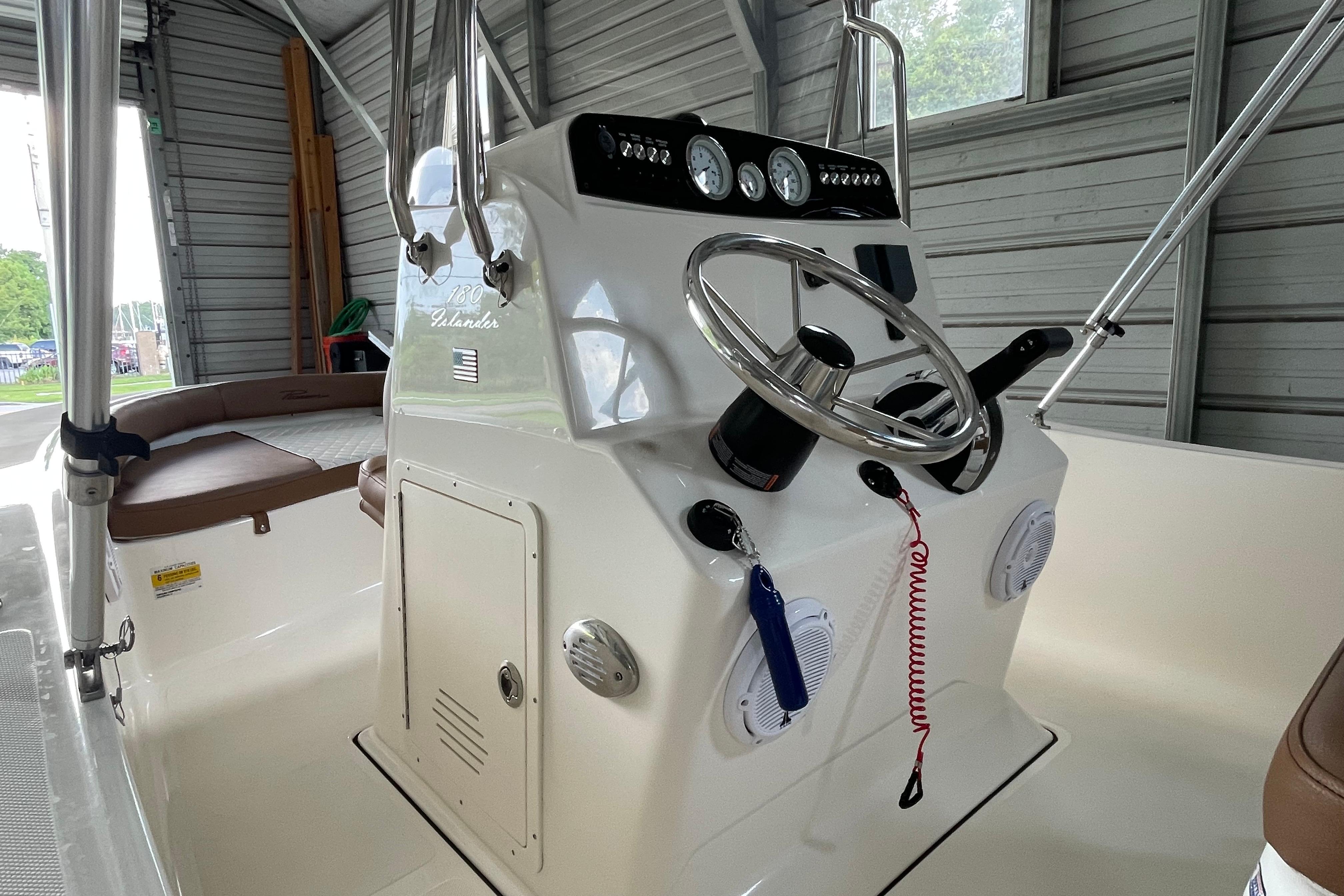 2024 Pioneer 180 Islander boat console with steering wheel and gauges in a garage setting.
