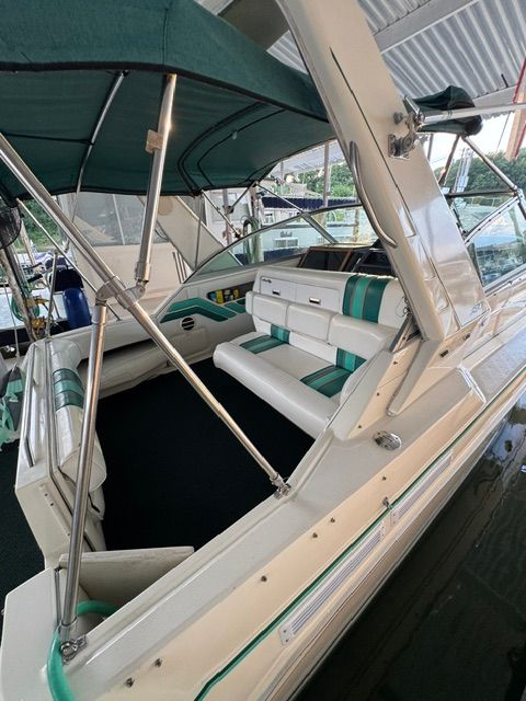 The image shows the cockpit of a 1992 Sea Ray 290 Sundancer with green upholstery.
