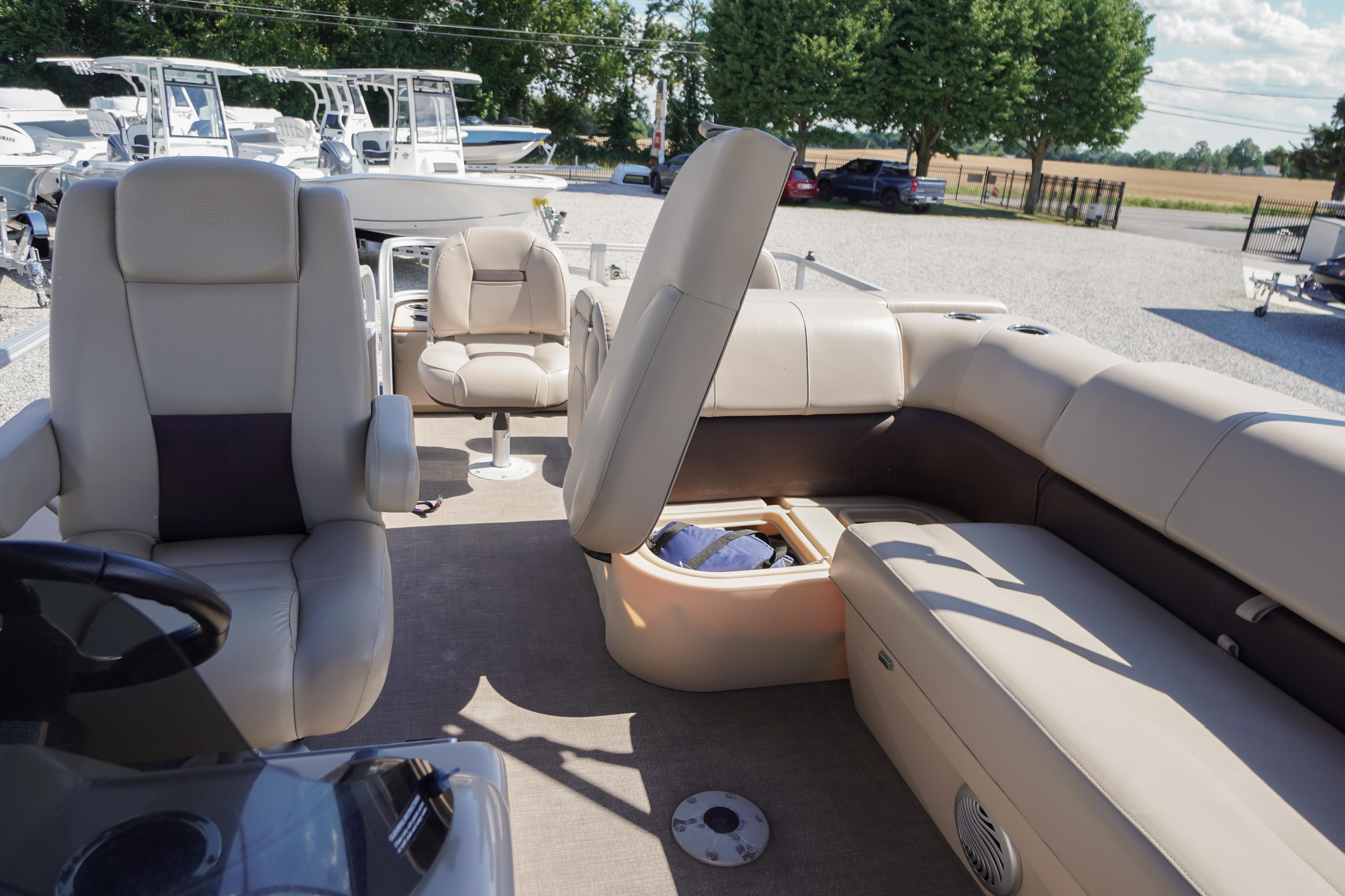 2019 SUNTRACKER Fishin' Barge 22 DLX interior with beige seating and storage compartment.