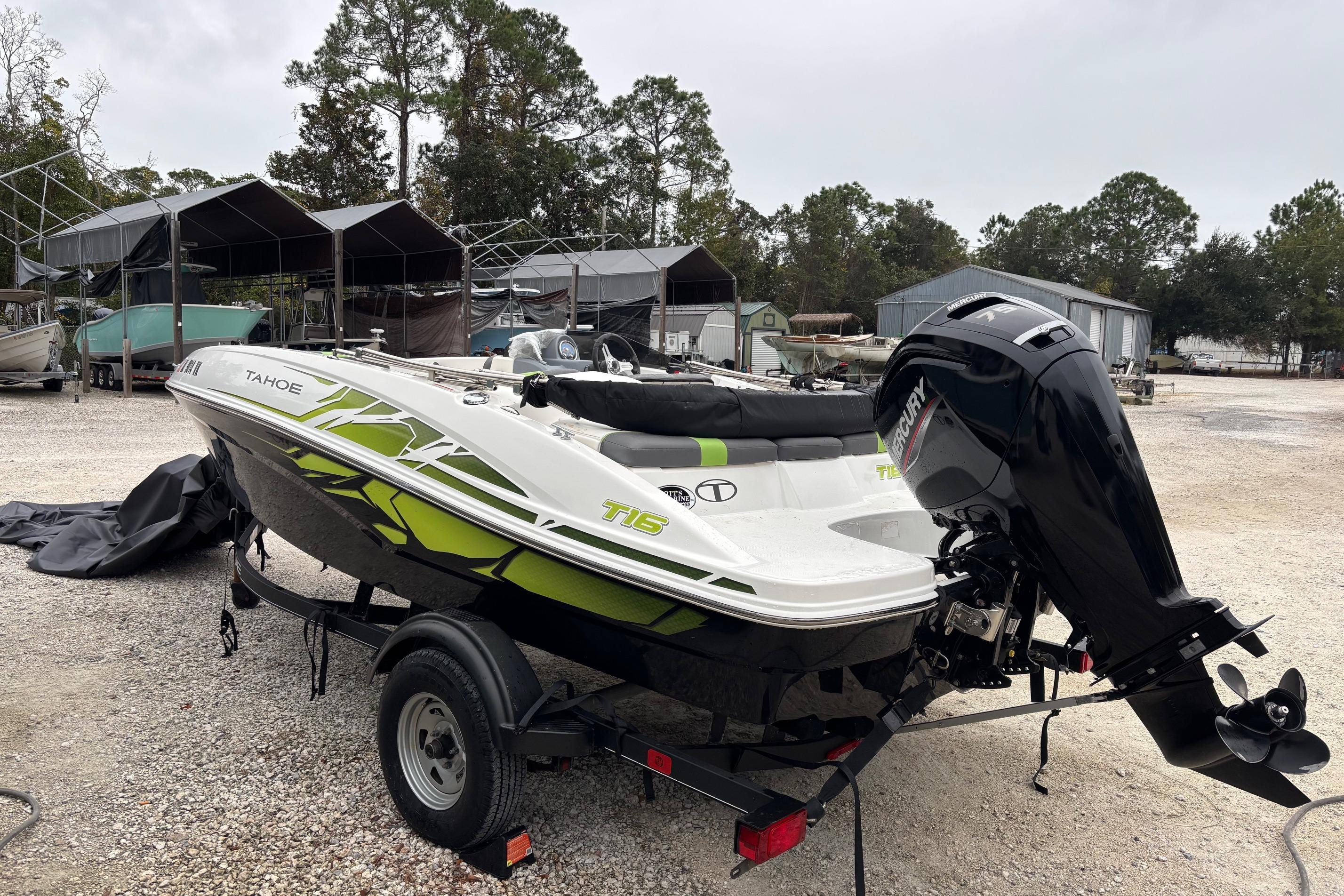 2022 Tahoe T16 boat with Mercury outboard motor on a trailer in a storage area.