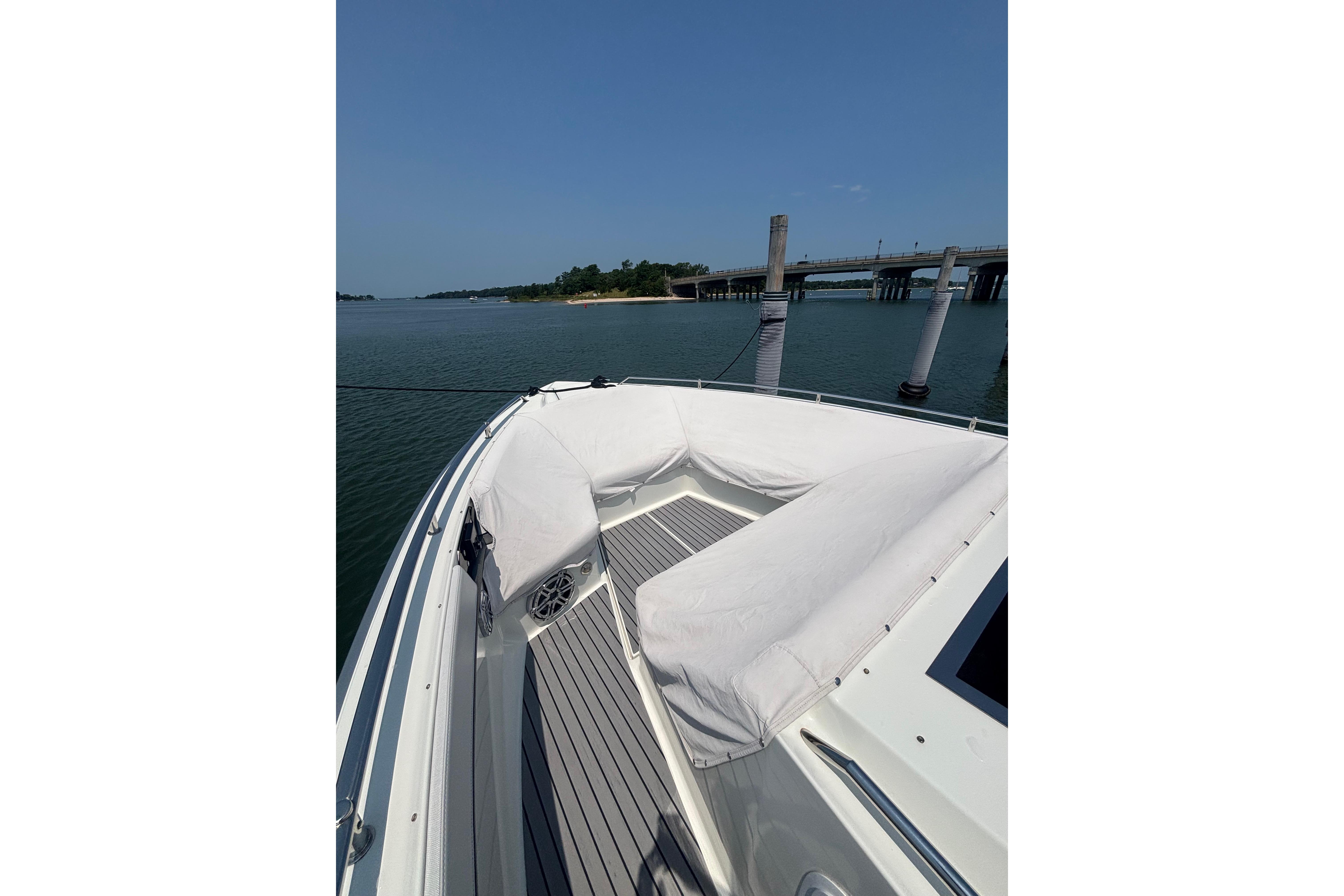 2019 Formula 430 Super Sport Crossover boat docked near a bridge on a sunny day.