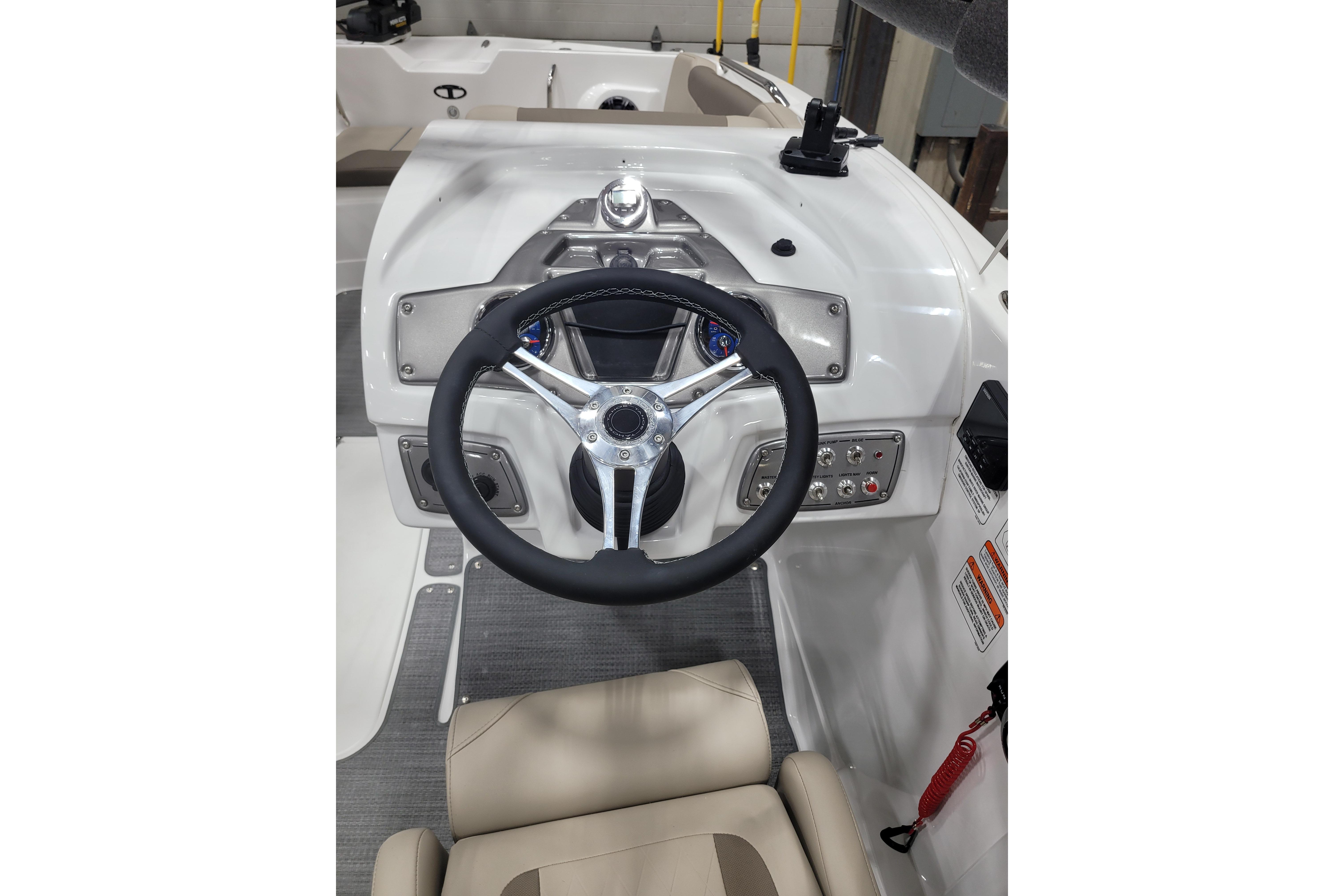 Steering console of 2026 Tahoe 2150 boat with modern controls and beige seating.