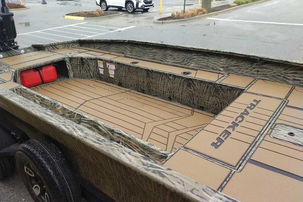 2026 Tracker Grizzly 1756 T Marsh boat with camouflage design in a parking lot.