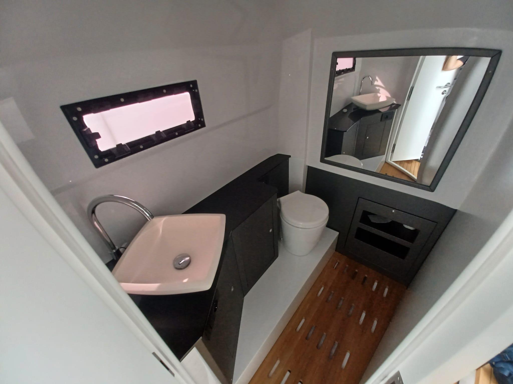 Modern bathroom interior in 2025 Pirelli PIRELLI 42 yacht, featuring sink, toilet, and mirror.