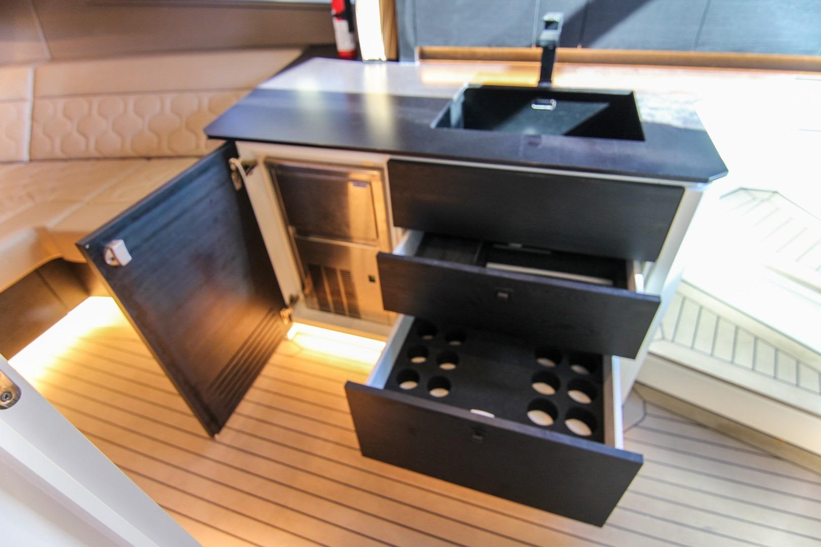 Luxurious interior of 2022 Vanquish Yachts VQ45 with modern kitchenette and storage.