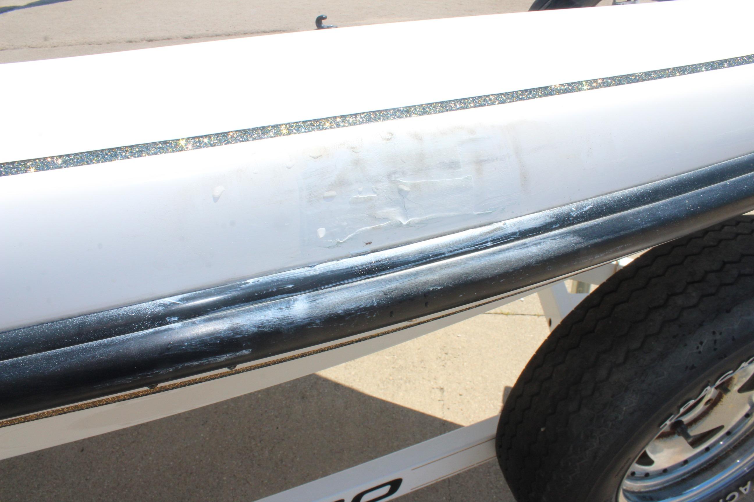 Close-up of a 2003 Nitro NX 750 SC boat hull with visible wear and scuff marks.