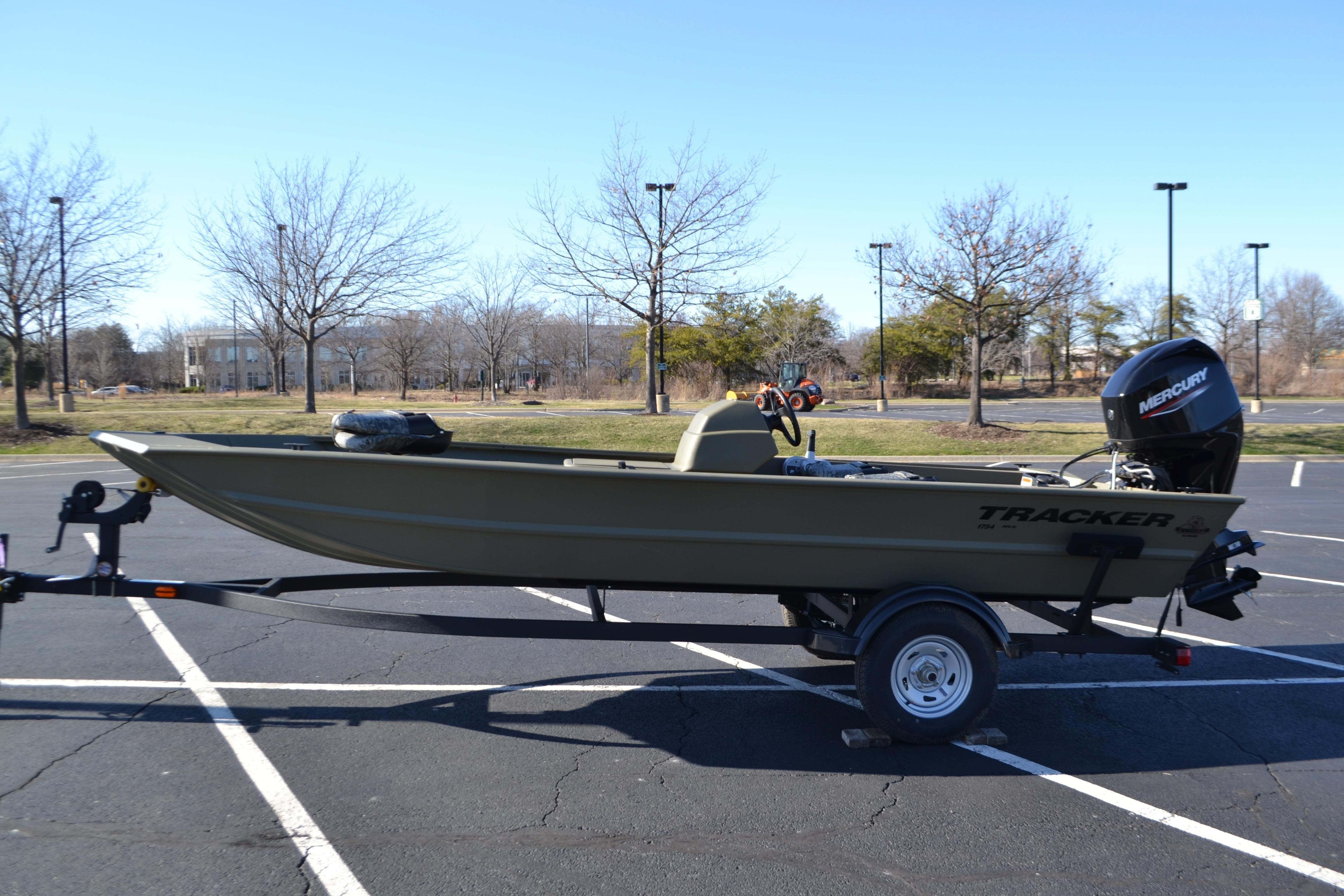 2026 Tracker Grizzly 1754 SC boat on trailer in parking lot, clear sky background.