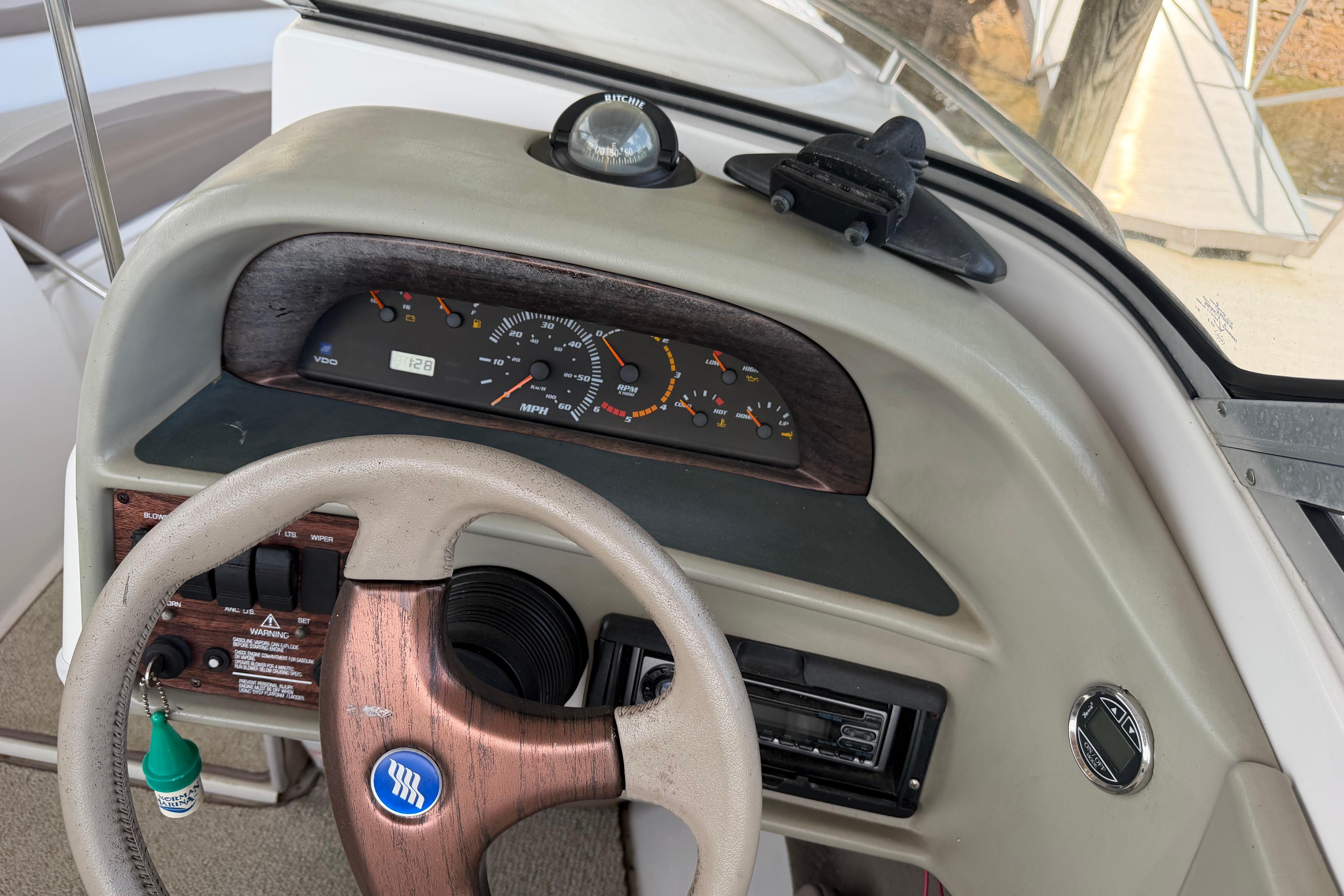 Steering console of a 1998 Four Winns 220 Horizon boat with gauges and controls.