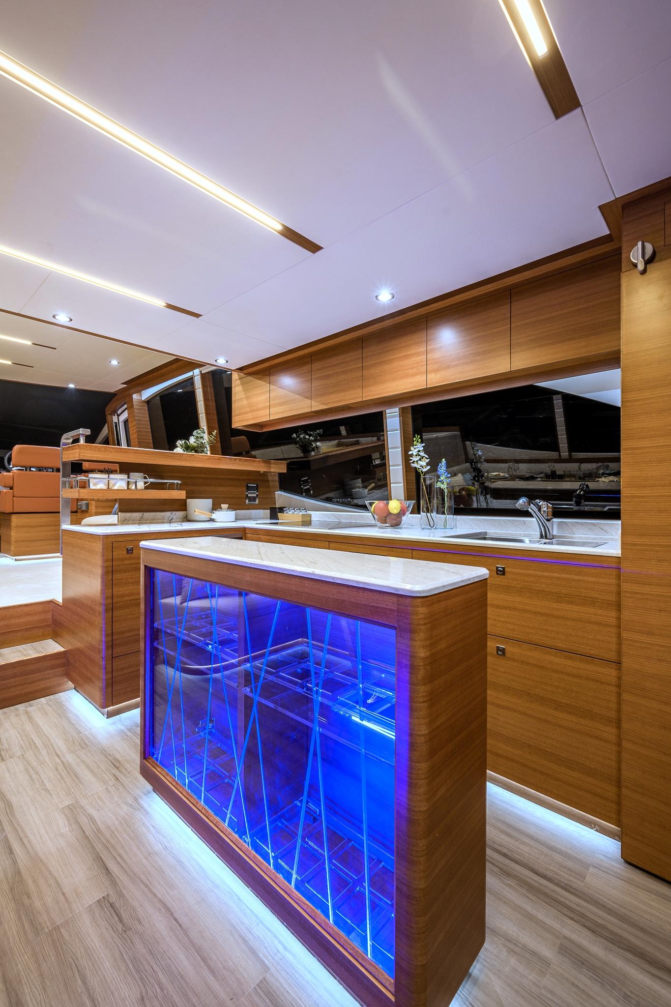 Modern kitchen interior of 2025 Dyna 63 yacht with blue LED lighting.