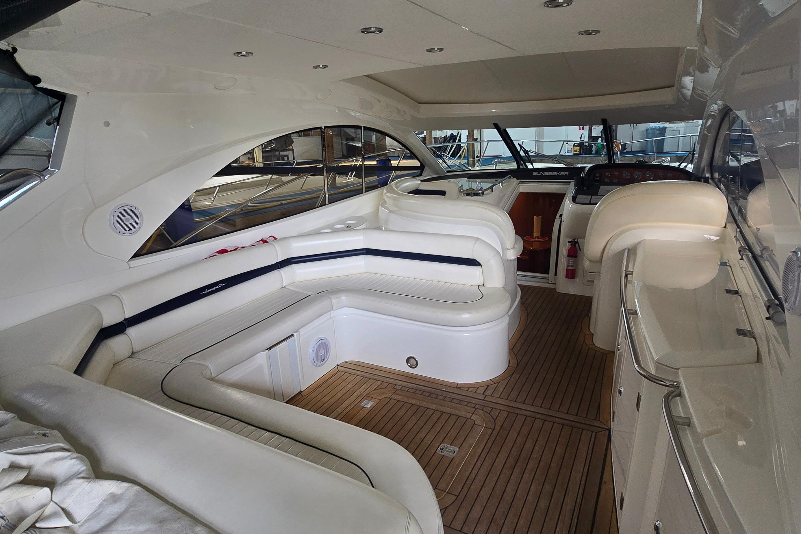 Luxurious 2004 Sunseeker Camargue 50 yacht interior with elegant seating and wood flooring.