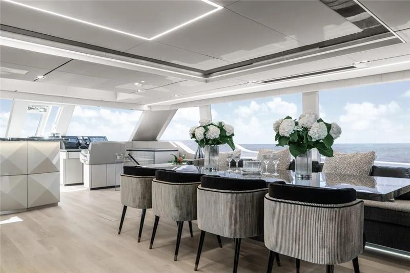 Luxurious interior of 2026 Sunreef 80 Power yacht with elegant dining area and ocean view.