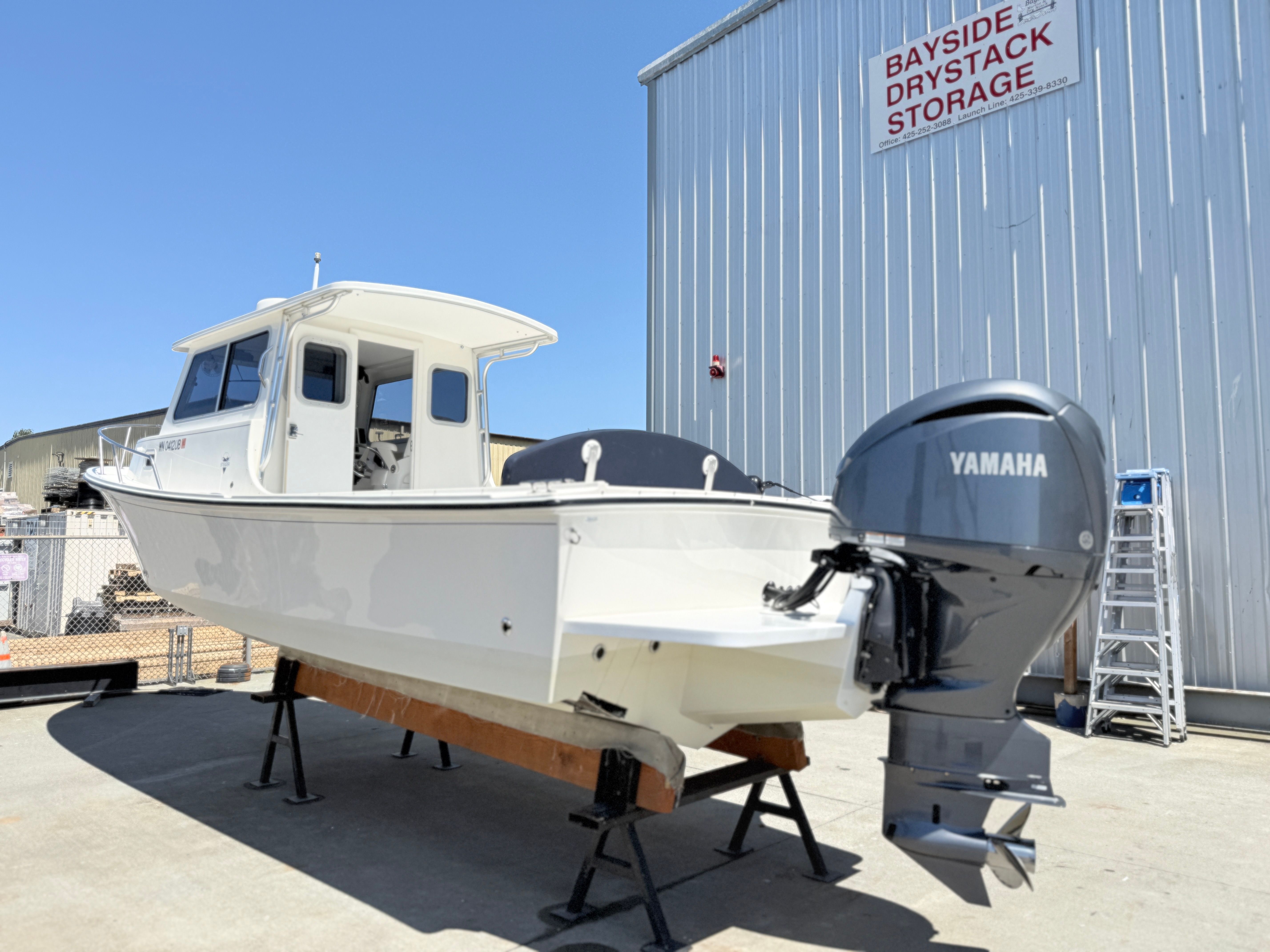 A 2015 Steiger Craft 255 Chesapeake boat on dry dock with a Yamaha outboard motor.