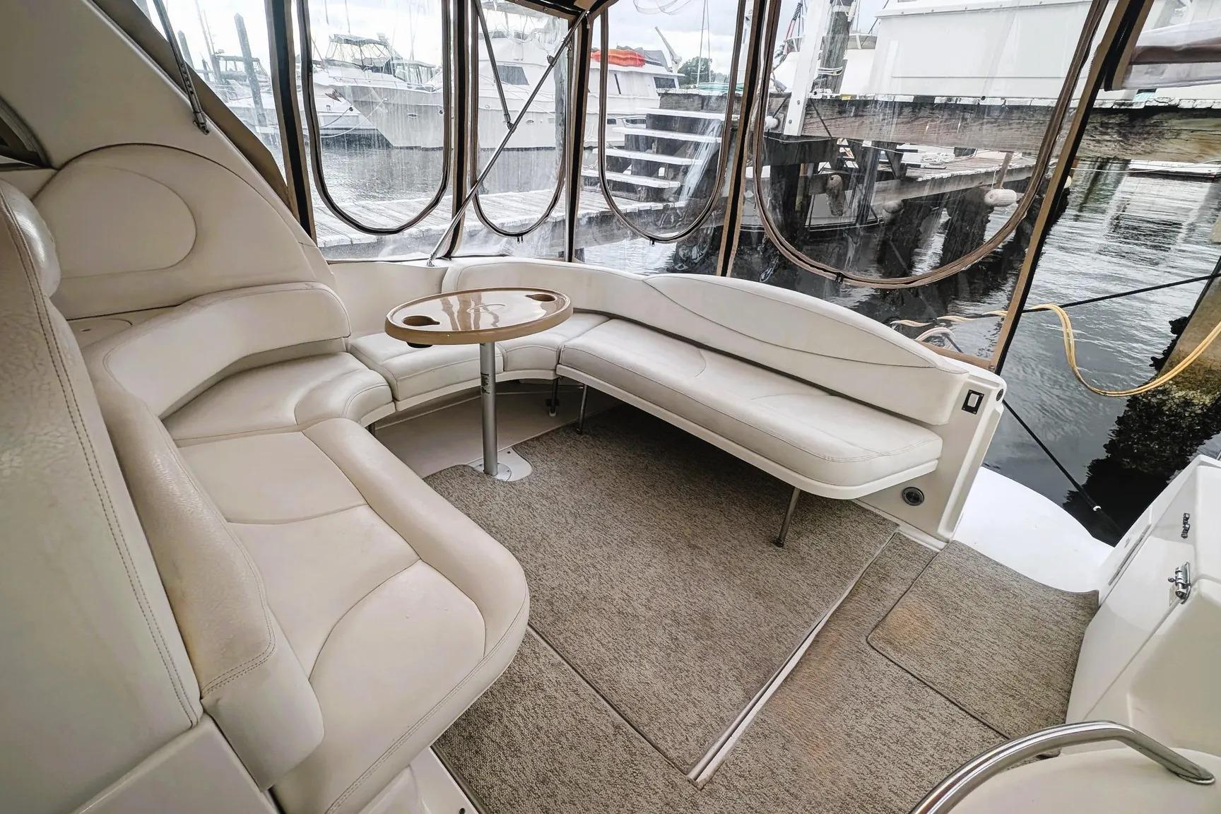 Luxurious interior of 2000 Sea Ray 380 Sundancer yacht with plush seating and table.