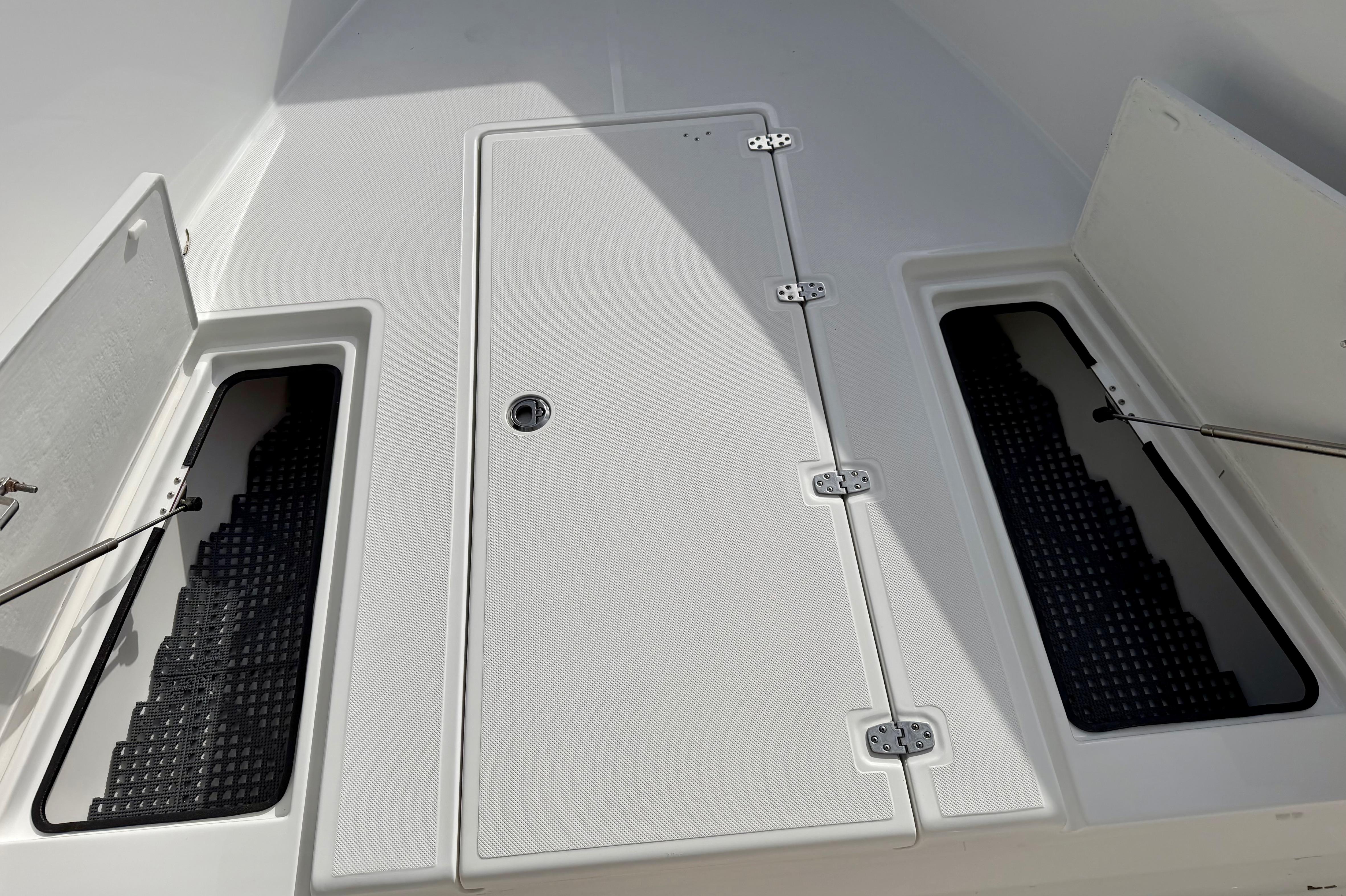 2025 Ocean Master 296 Center Console boat deck with storage compartments open.