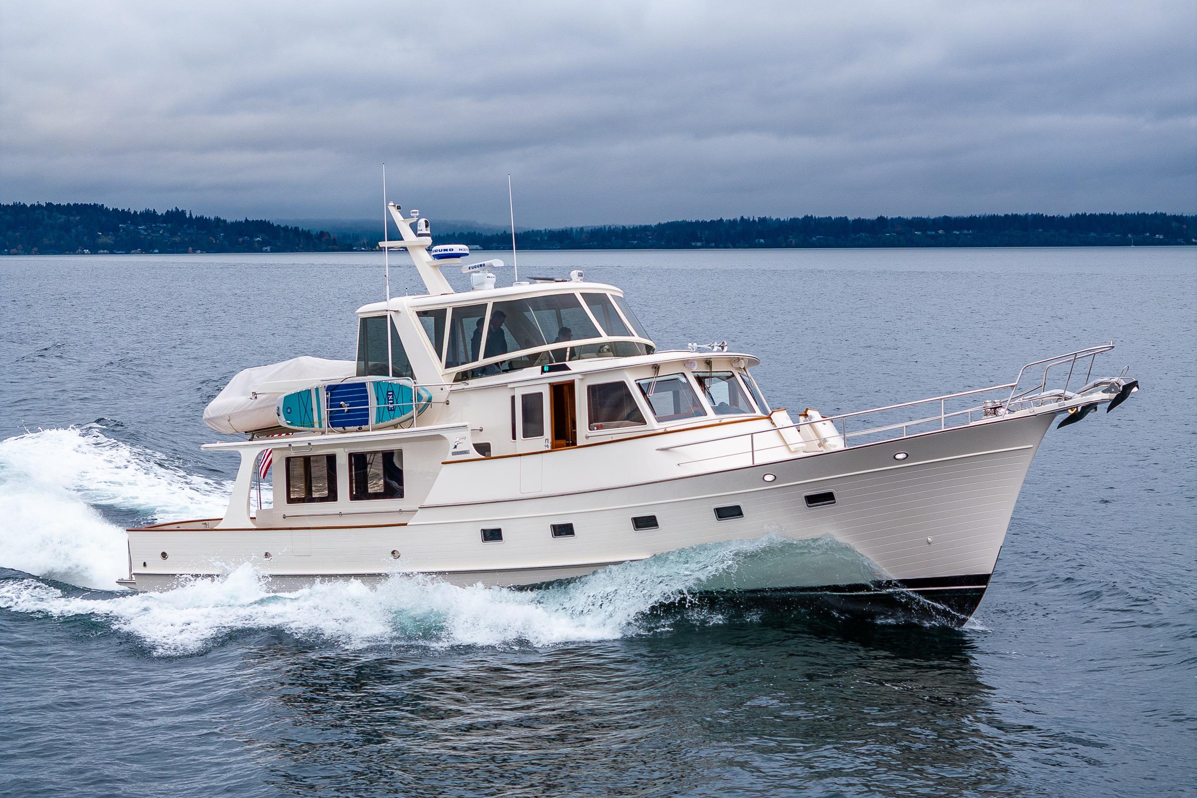 2026 Fleming 55 Pilothouse yacht cruising on open water under cloudy skies.